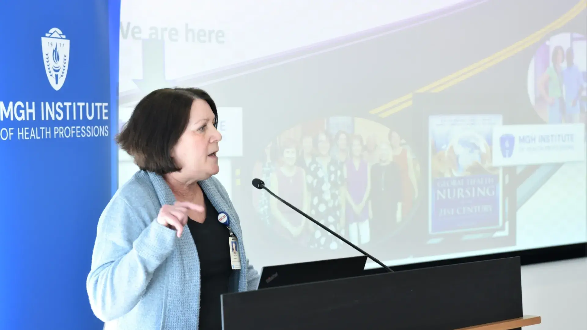 woman stands at podium and gestures in the air