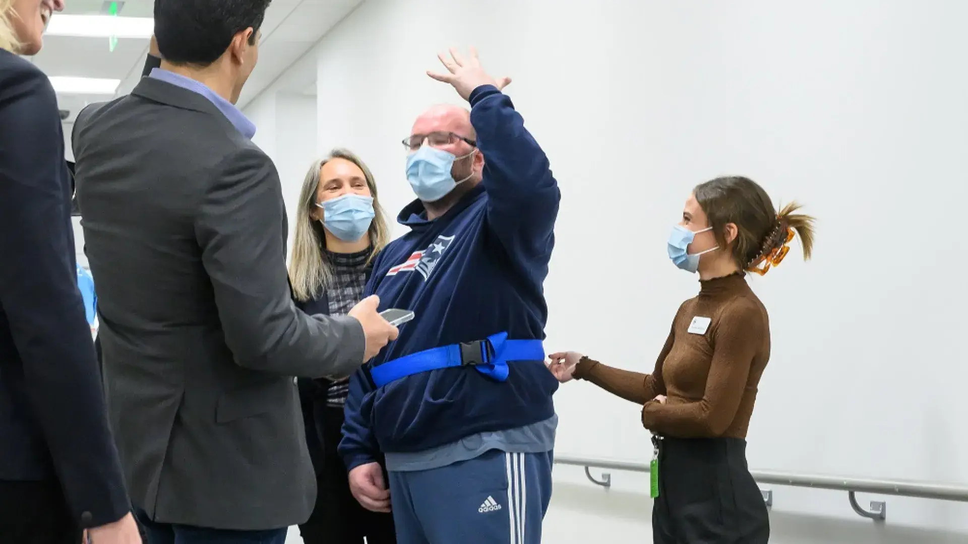 woman holds a belt around a man next to a ladder on the floor