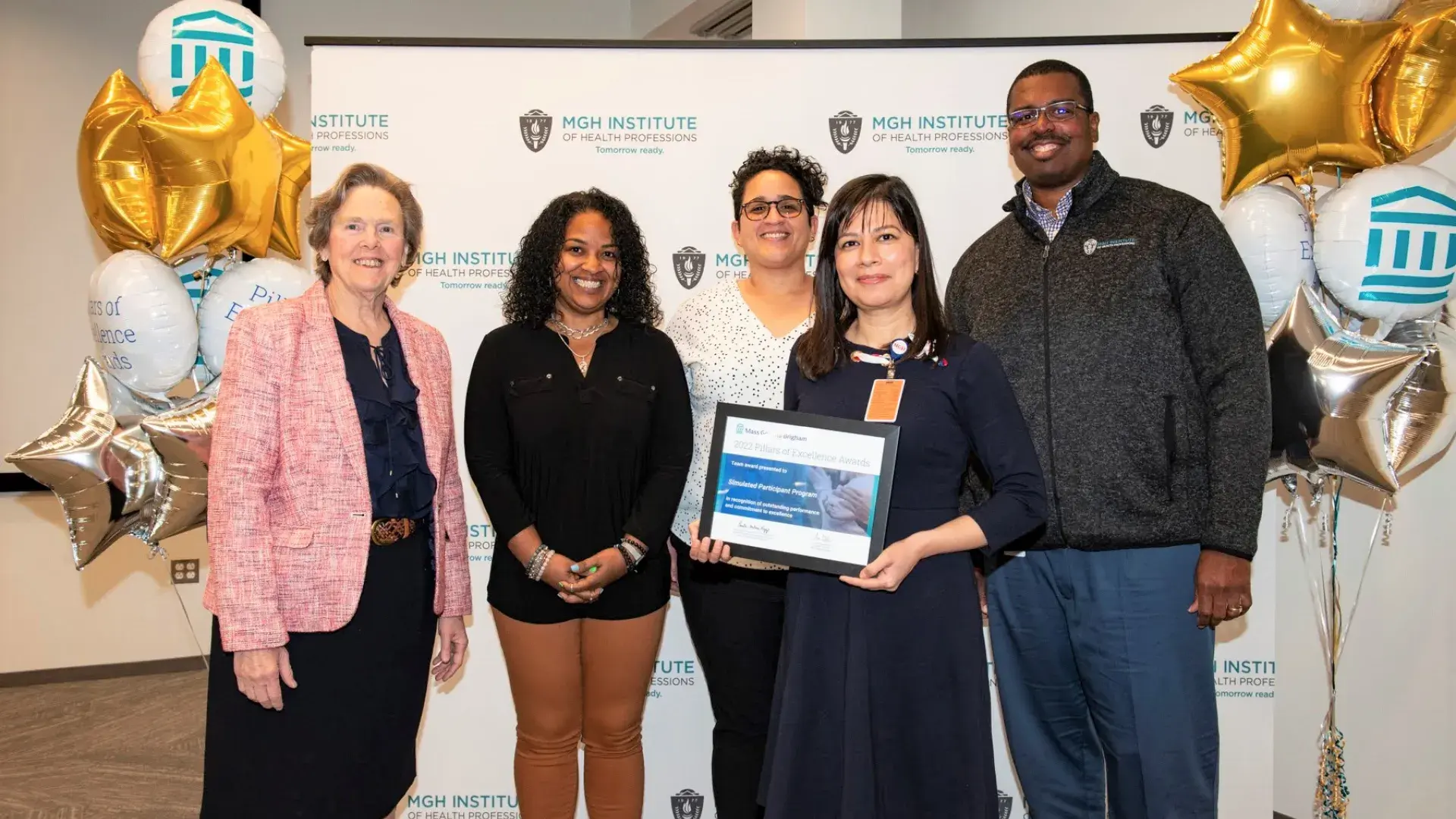 group stands next to balloons