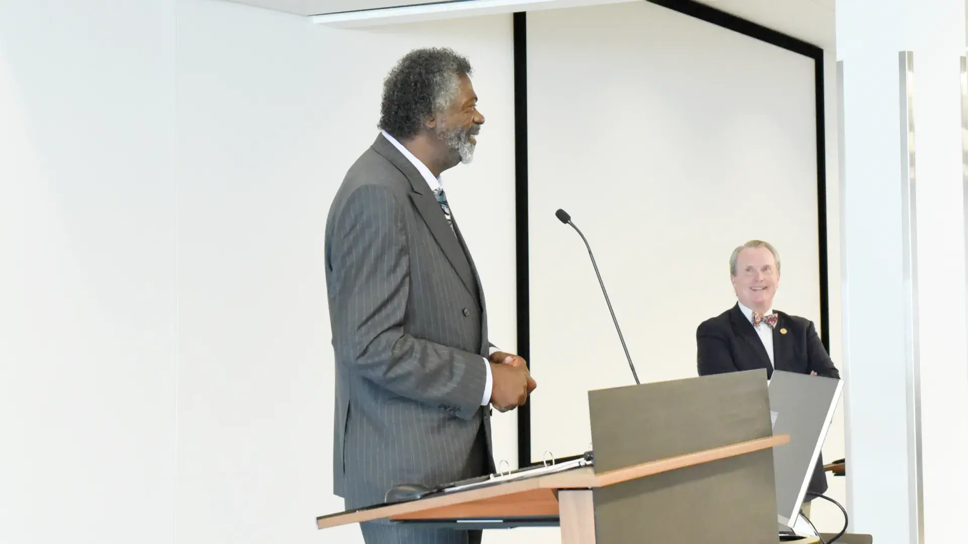 Black man in grey suit speaks