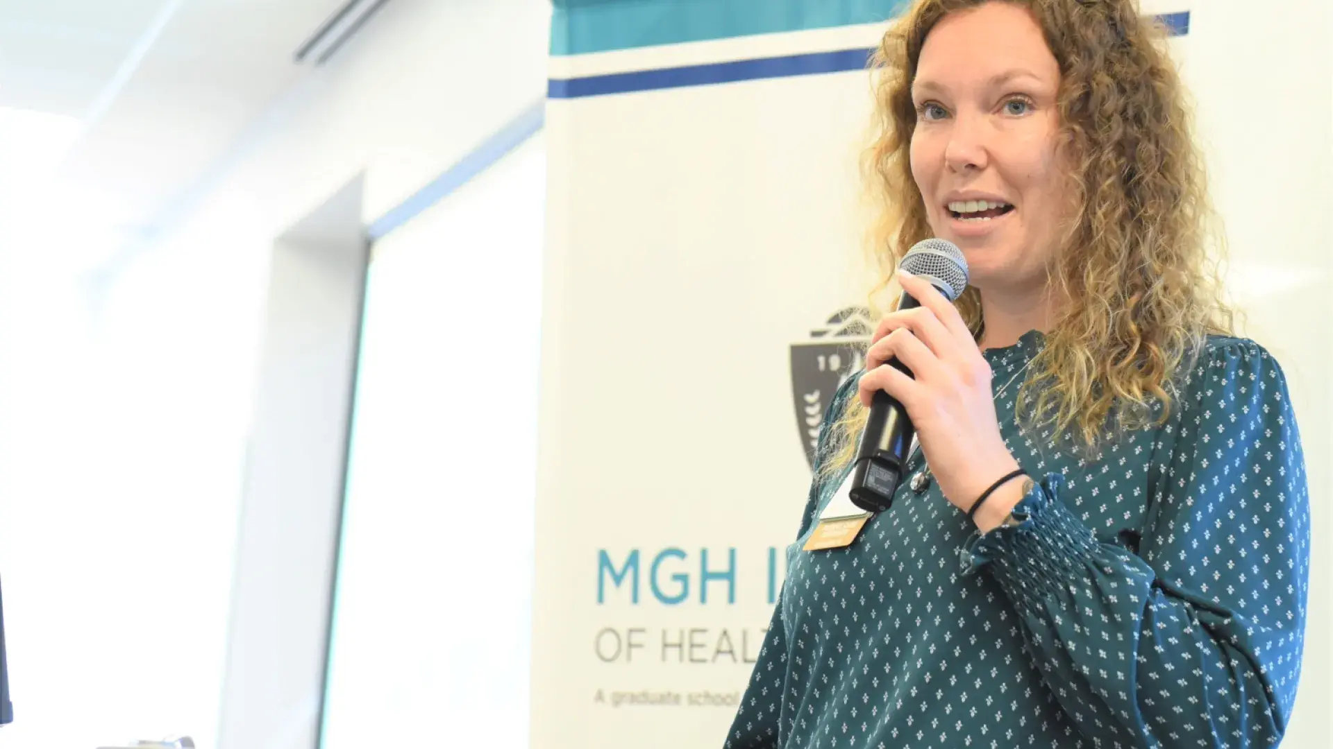 helen stands with a microphone