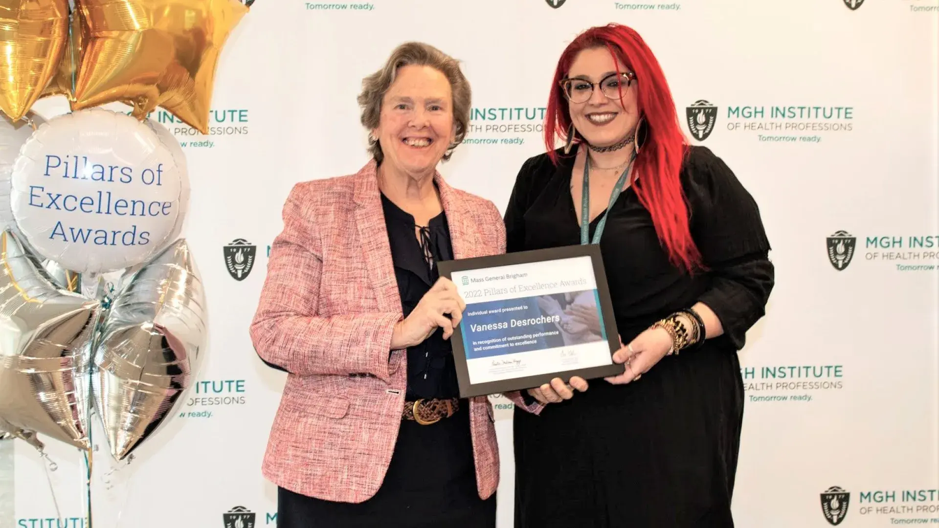 paula holds an award with vanessa