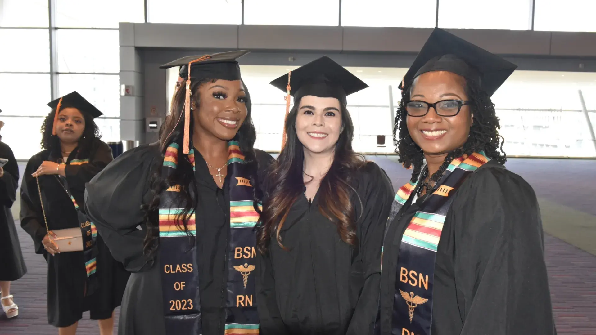 three women in regalia