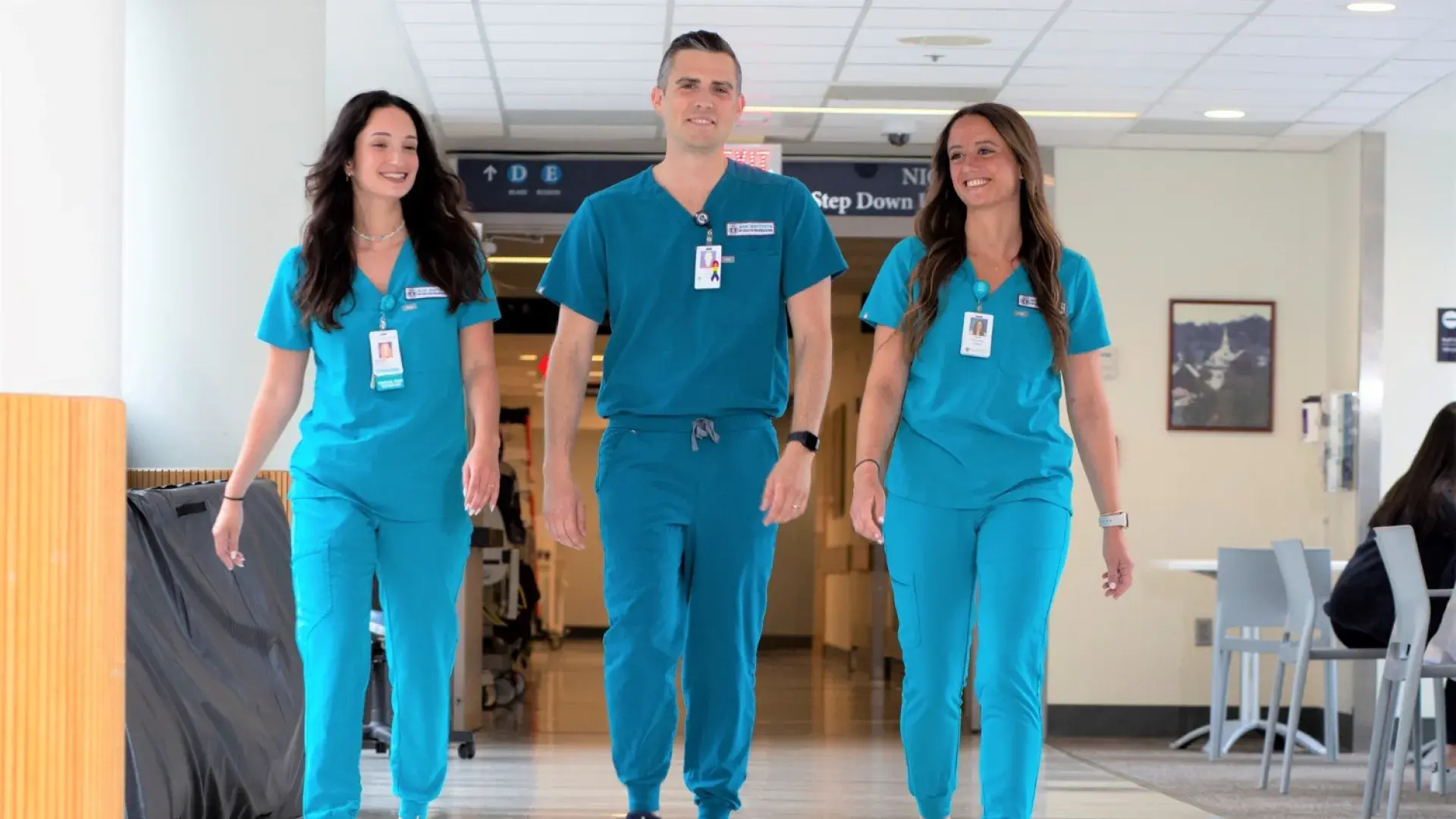 Three nursing students in scrubs walking in  MGH corridor