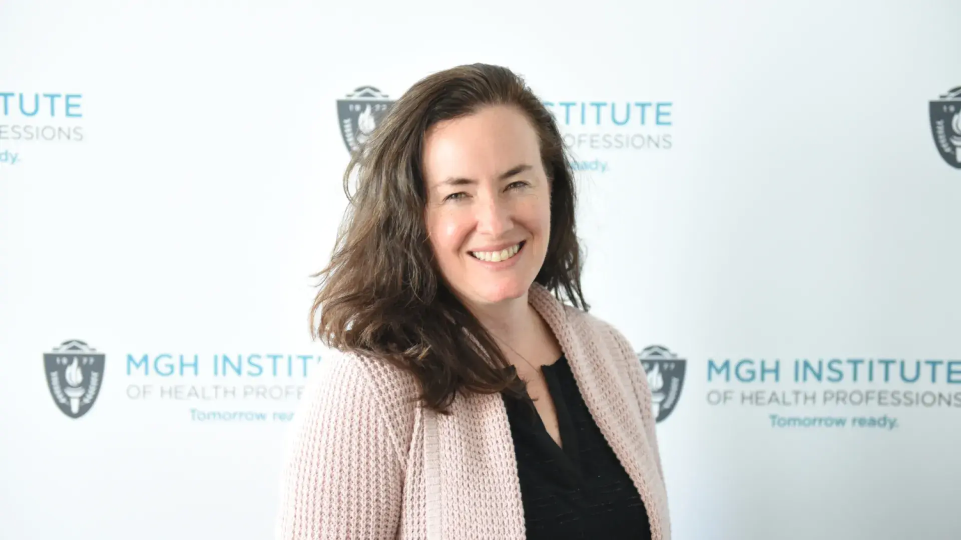 woman stands in front of banner