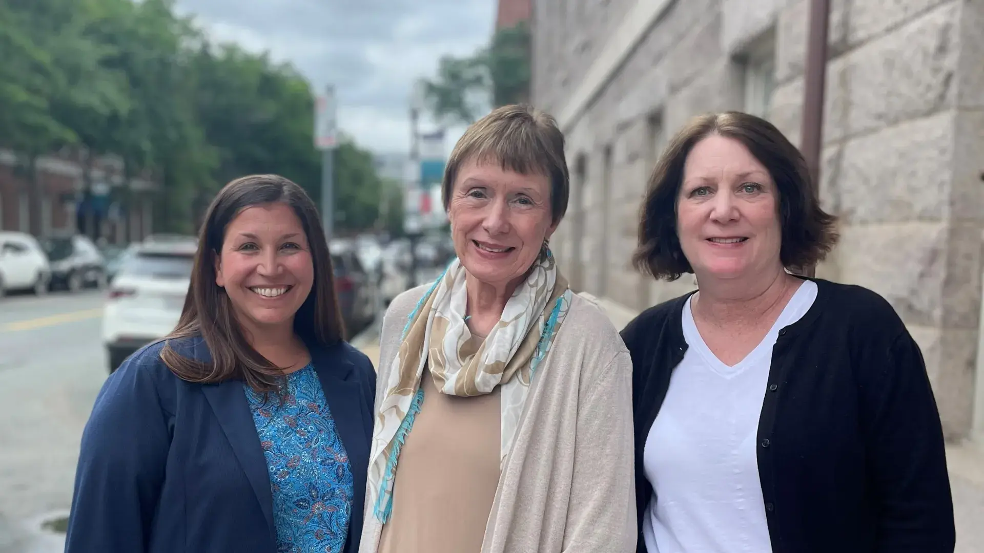 three woman standing on sidewalk