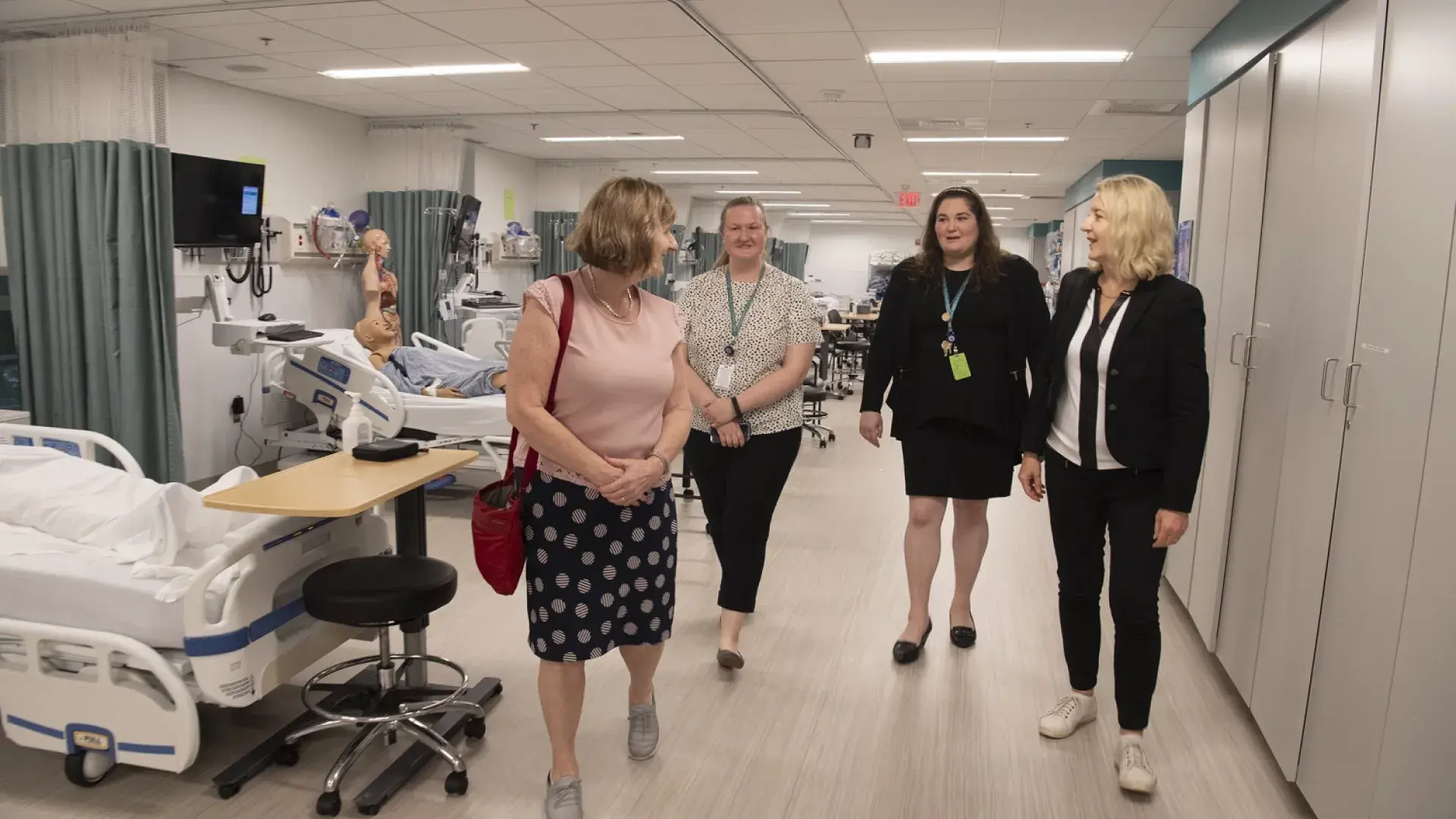 Four women walking in a nursing lab