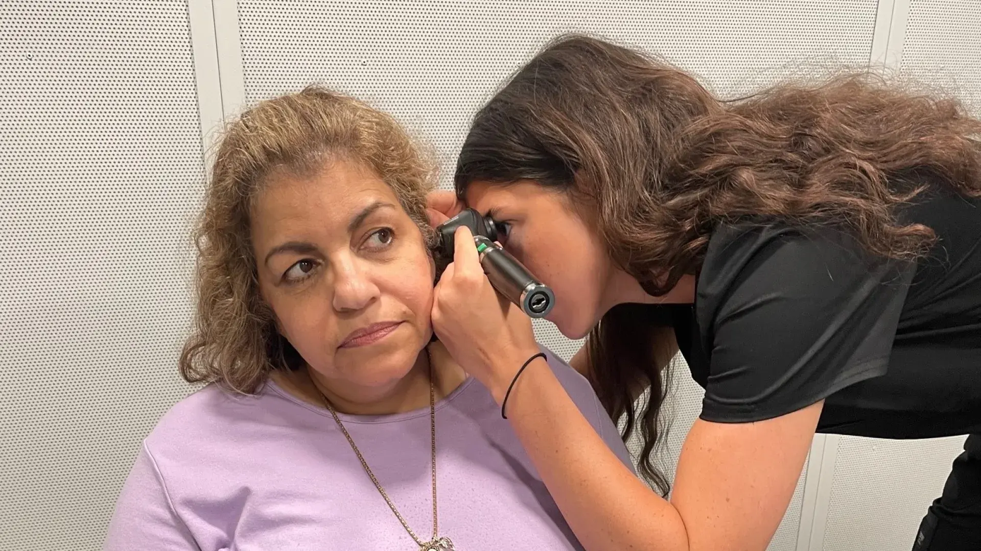 Woman uses an instrument to look in ear of a woman