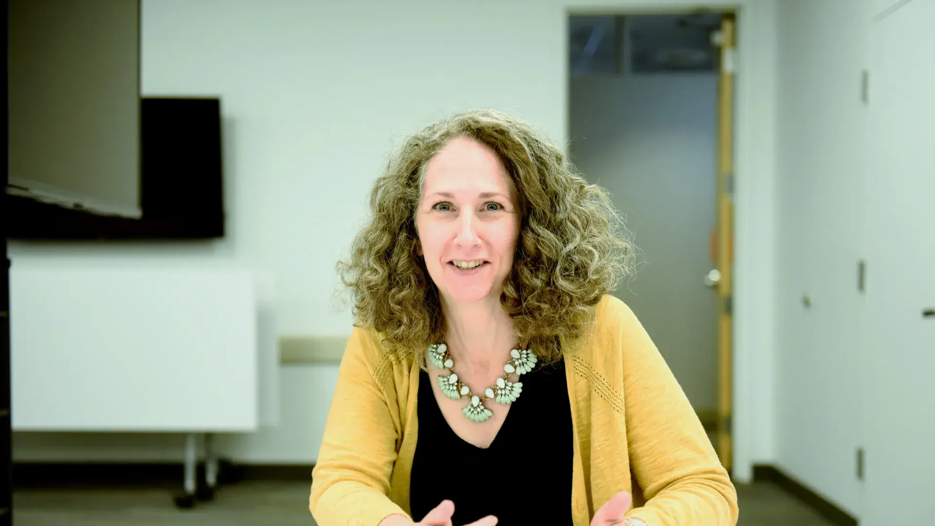 Woman wearing yellow sitting at table
