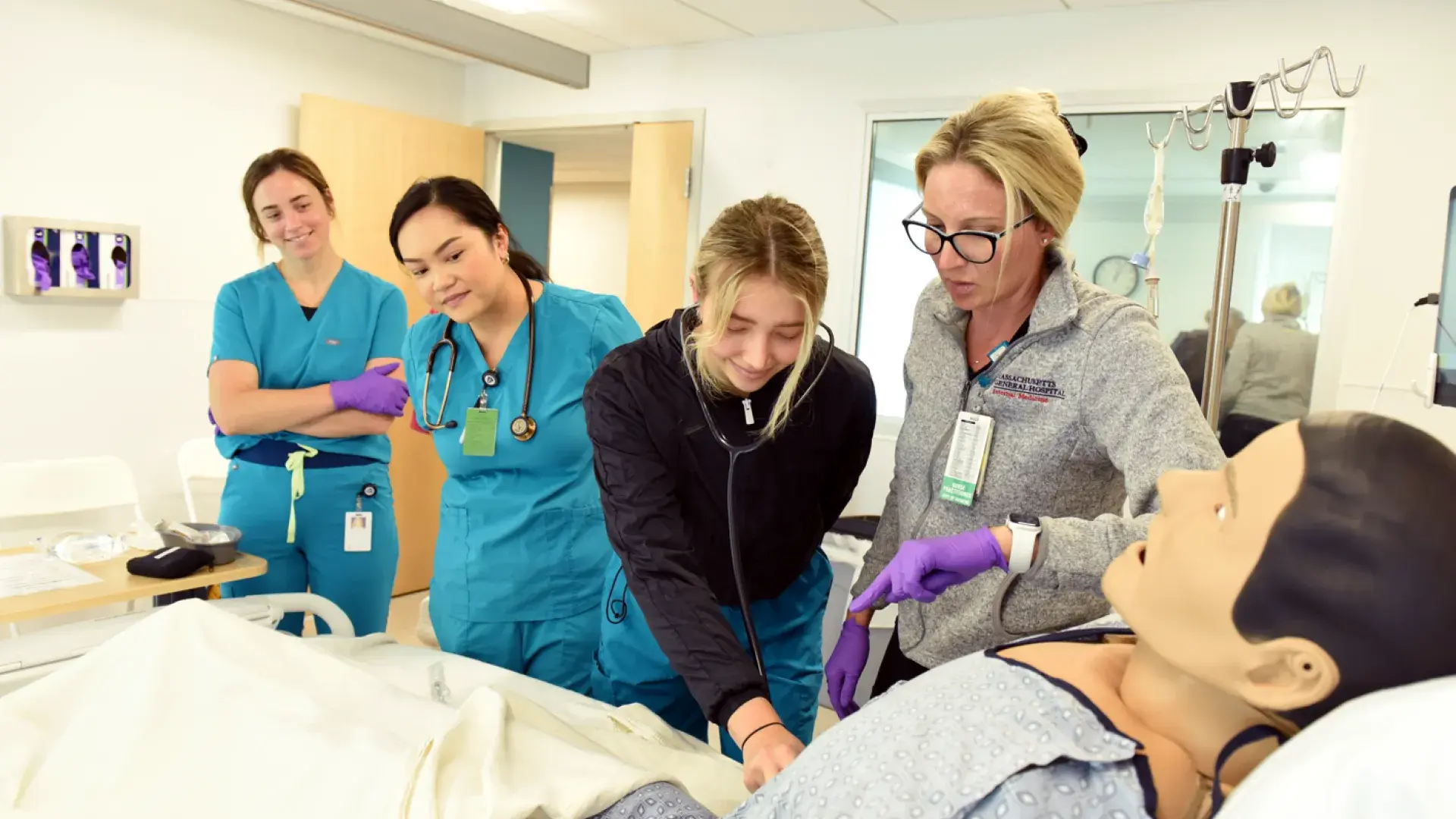 Nursing sim lab with instructor, students, and manikin