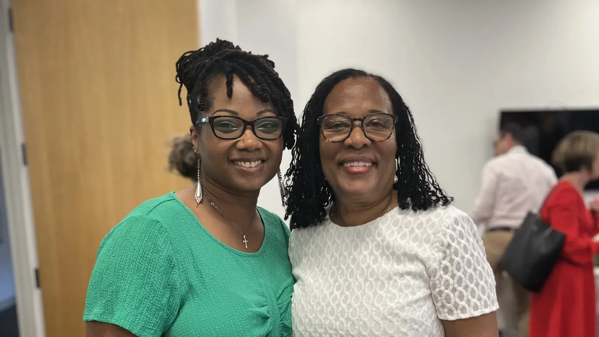 Two women stand and smile
