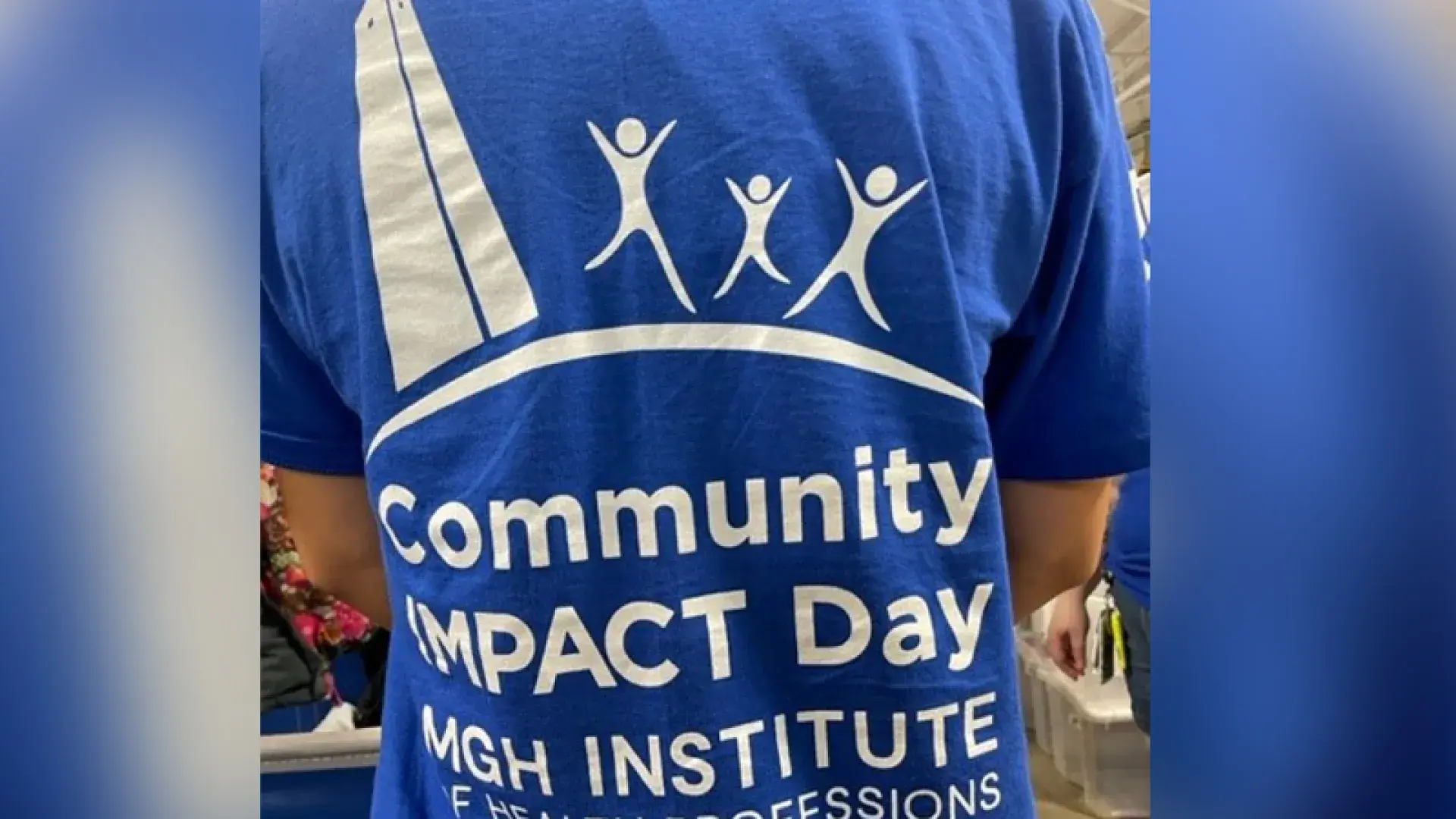 blue shirt with white lettering says Community IMPACT Day with stick people next to an illustration of the bunker hill monument (large rectangle)