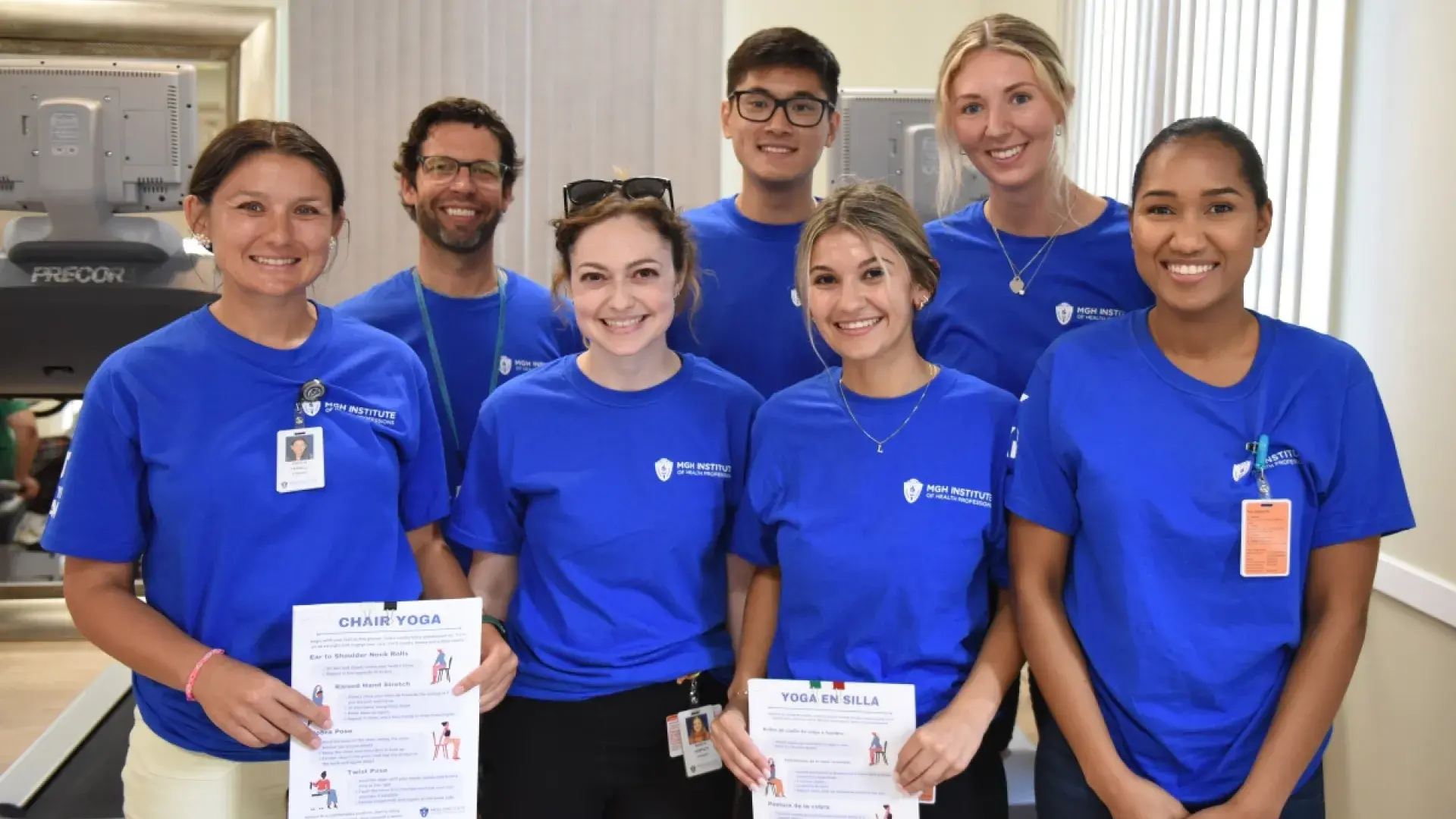 8 people in blue shirts smiling
