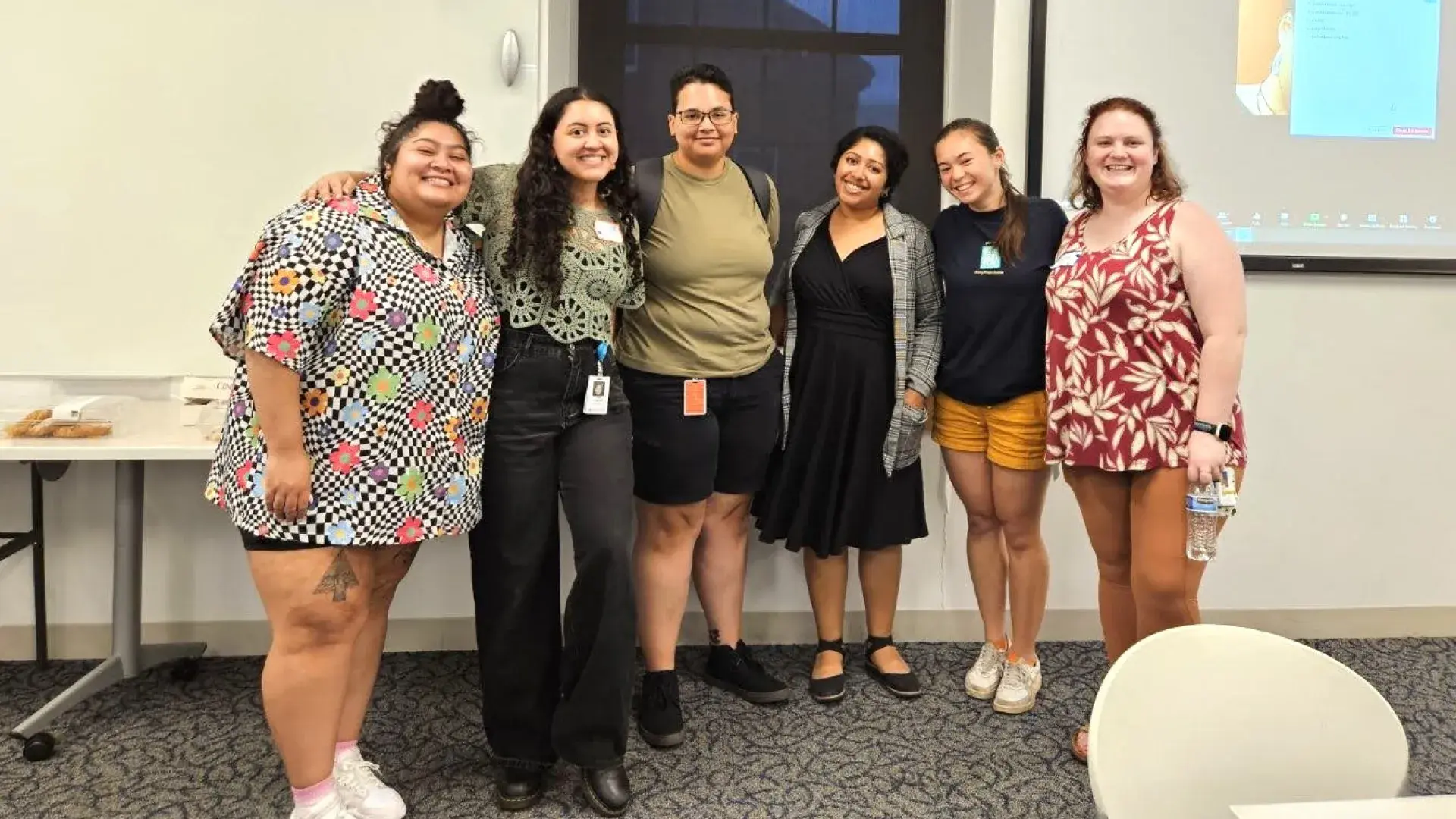 Six people in a row and smiling