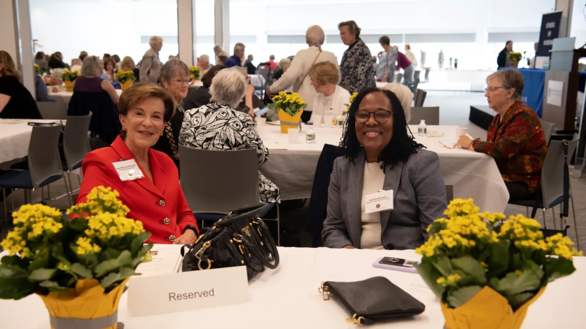 Two women smiling, sitting at table