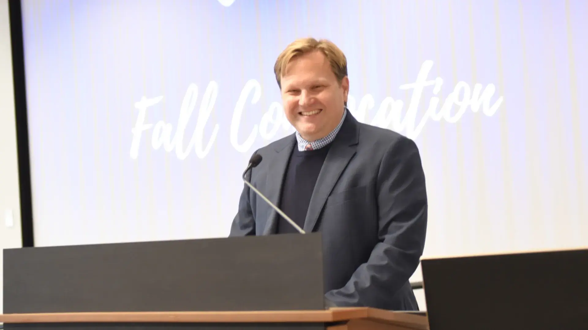 Man smiling at podium