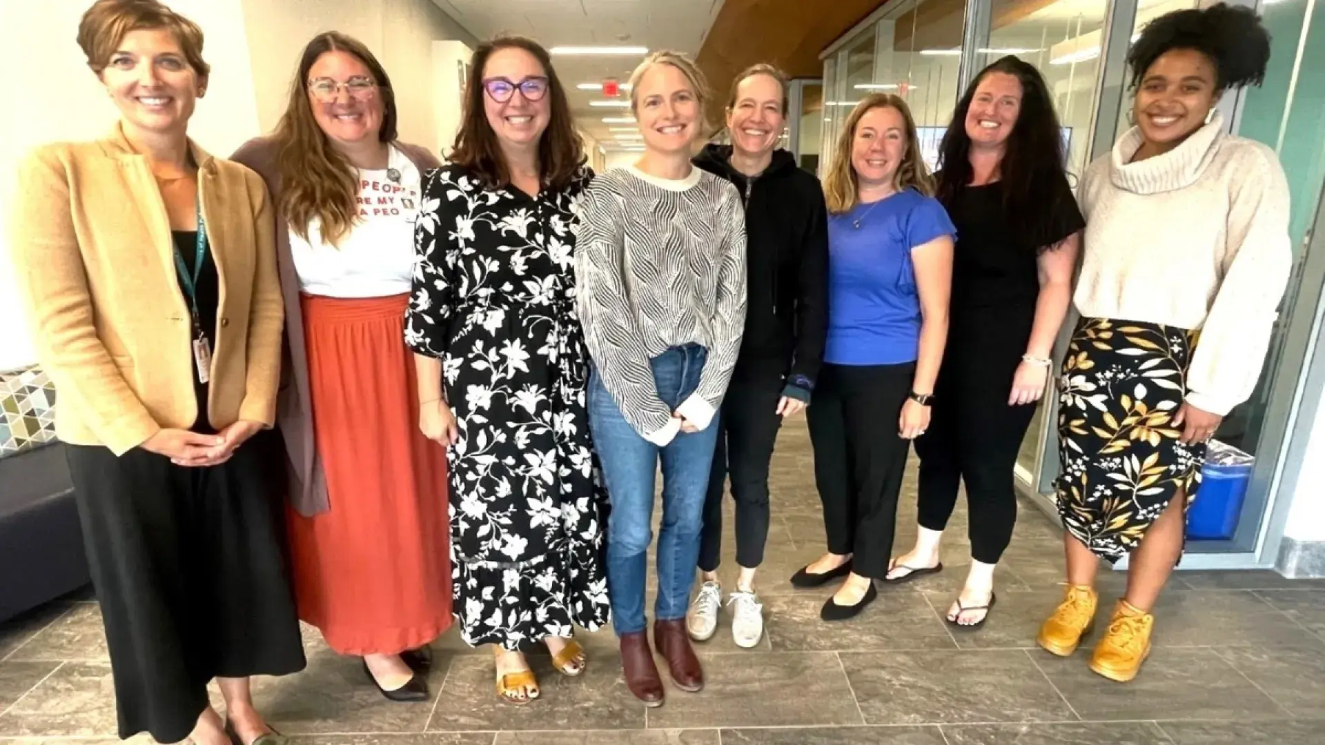 8 people standing and smiling