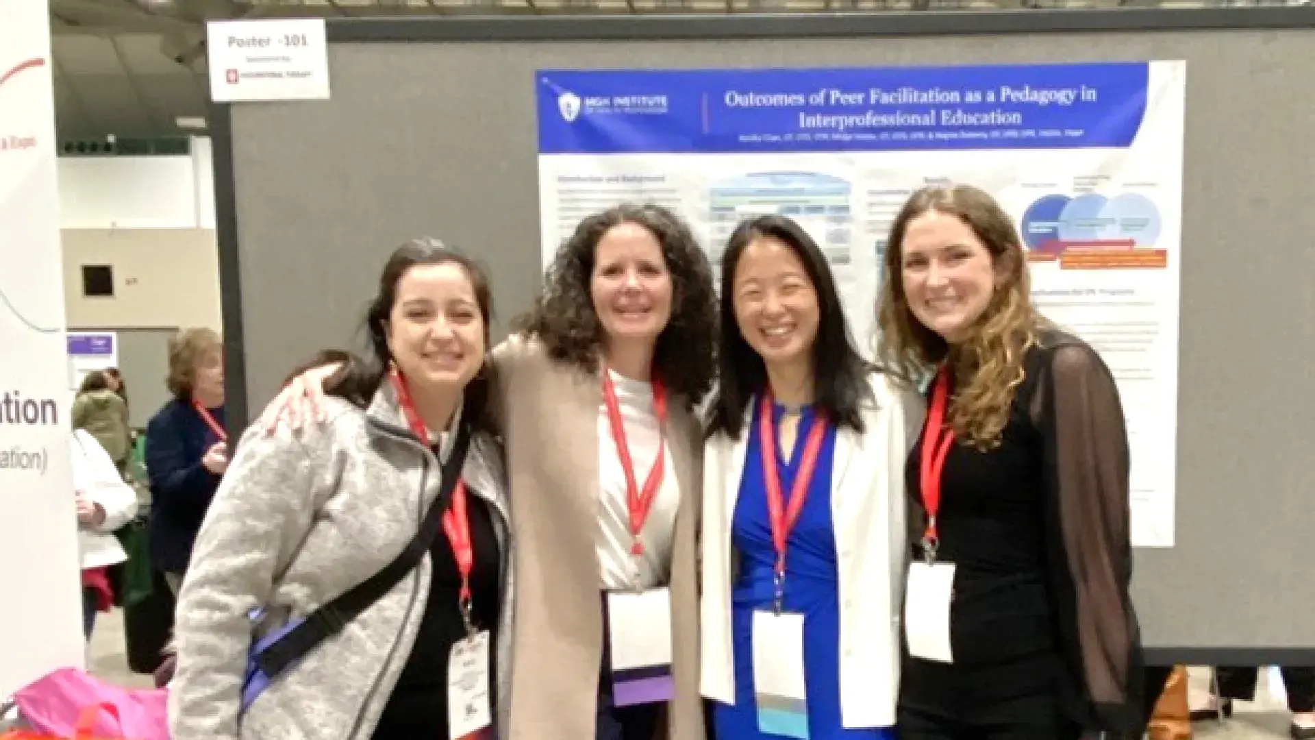 Four people smiling and standing