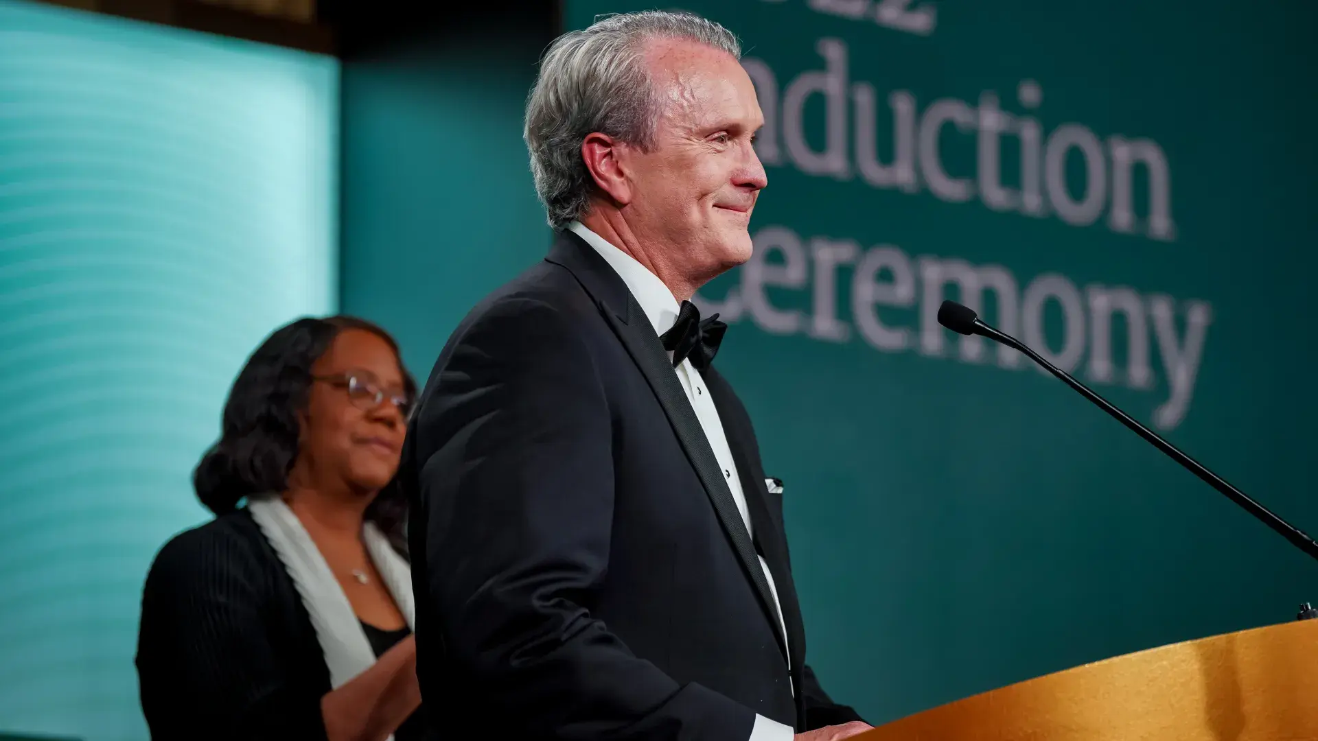 Man stands at podium side profile
