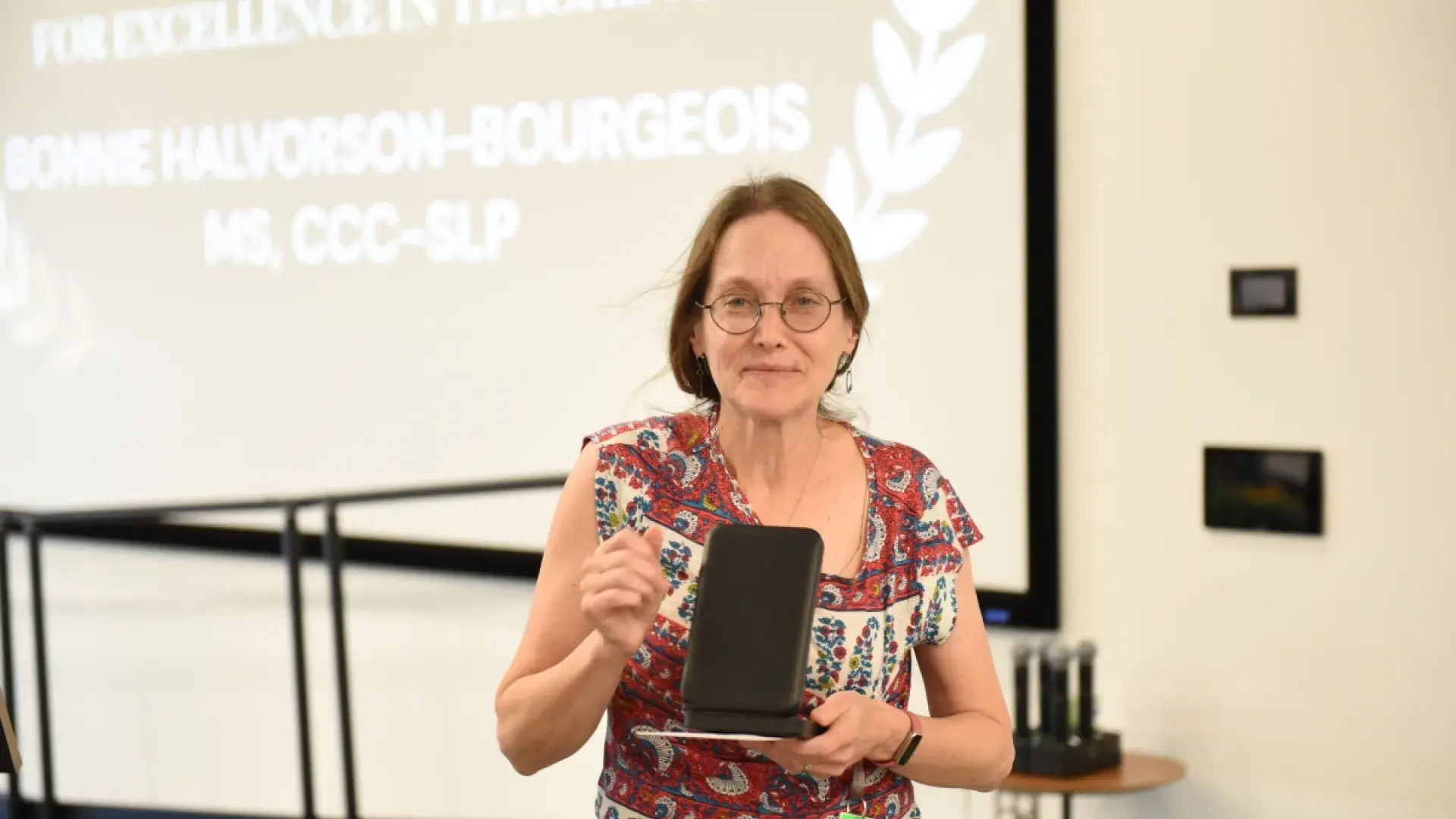 Woman with glasses holding a box