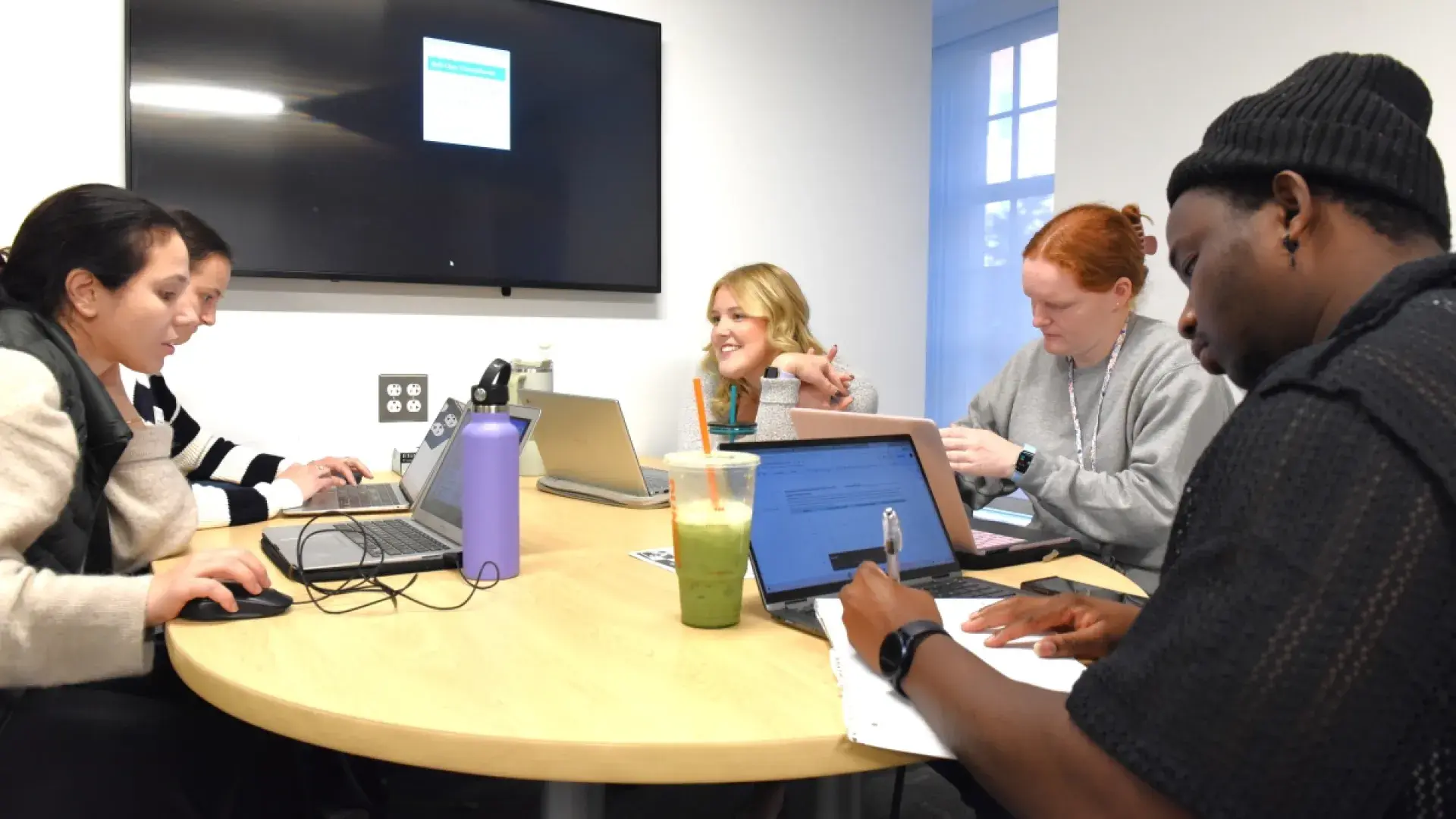 Students working and talking sitting around a table
