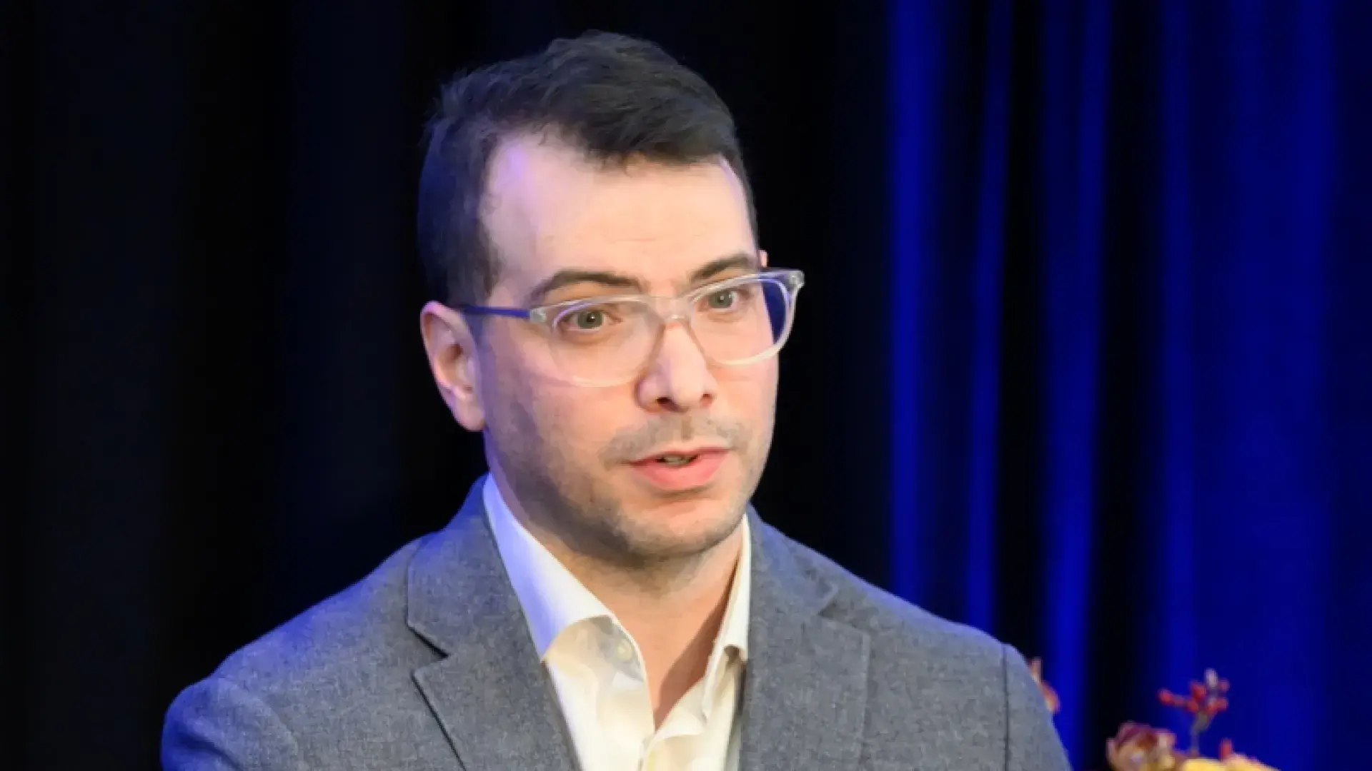 Man with glasses gestures