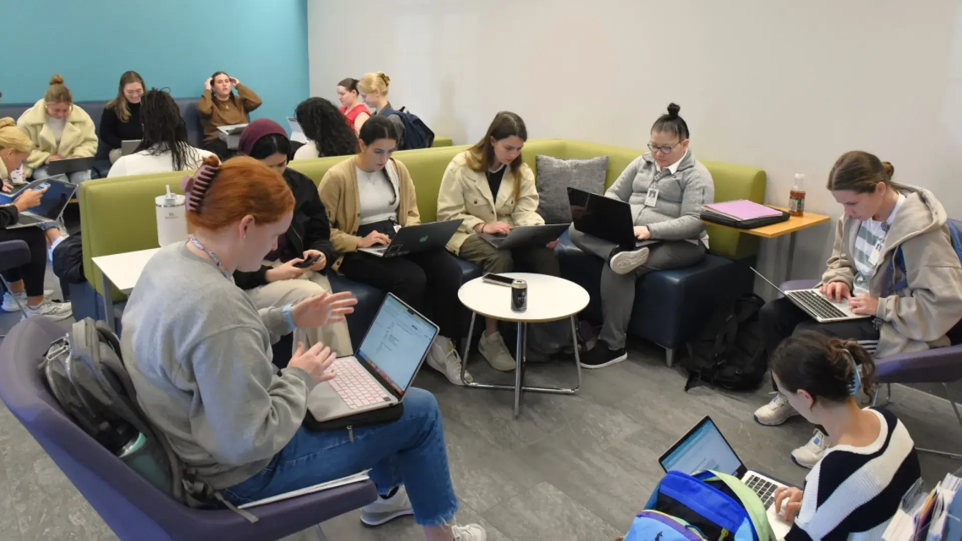 Students sitting on couches and chairs working on their laptops