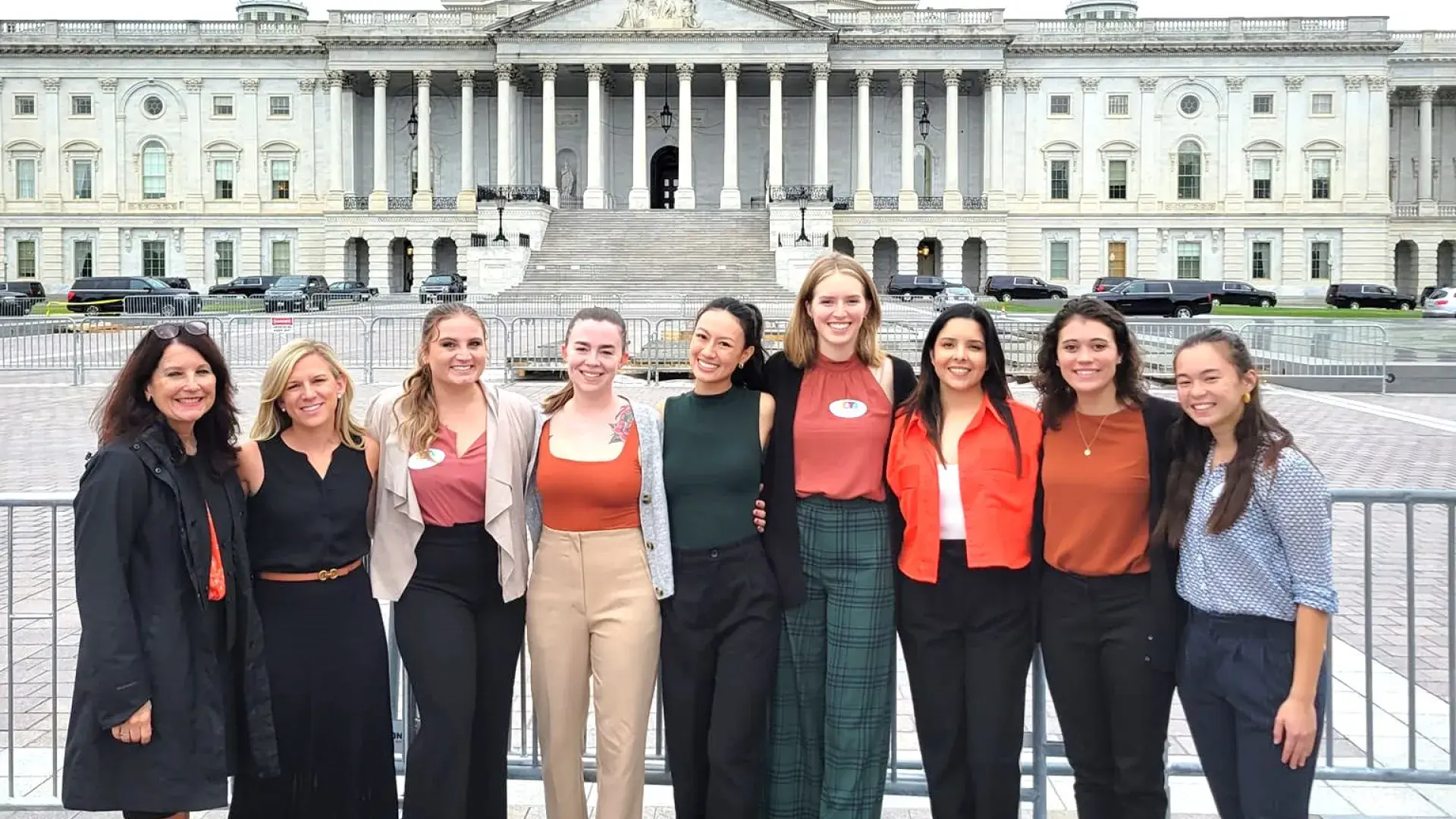 9 people standing in front of the US Capitol