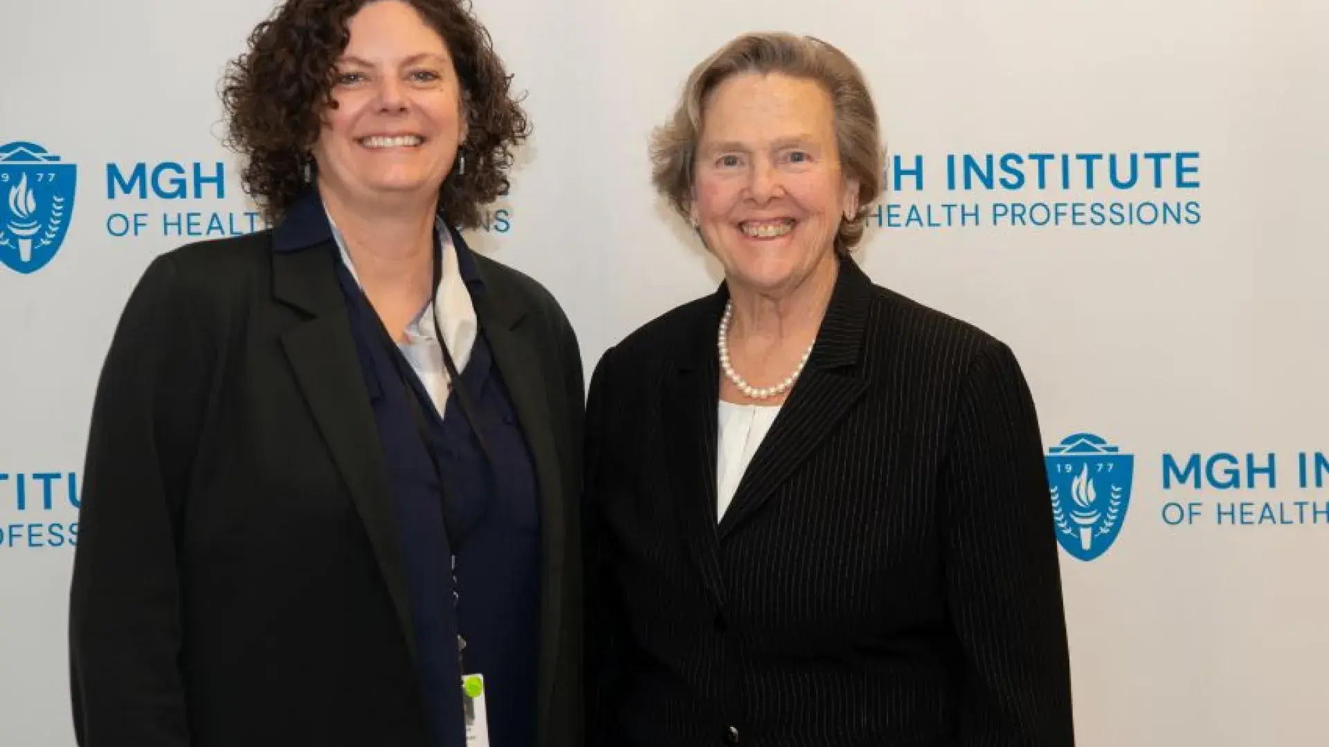 Two women pose and smile