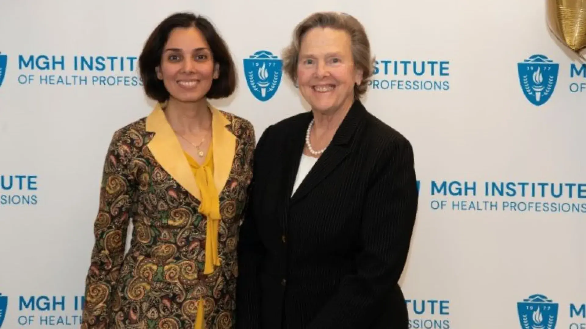 Two women pose and smile