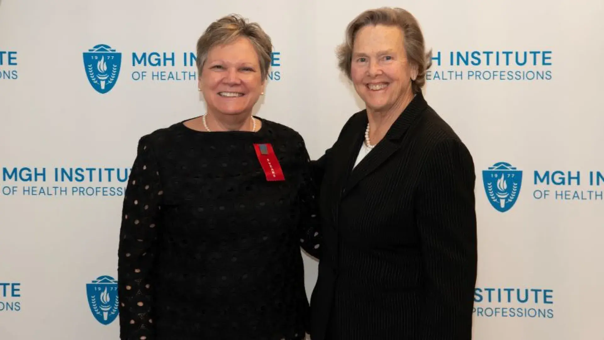 Two women pose and smile