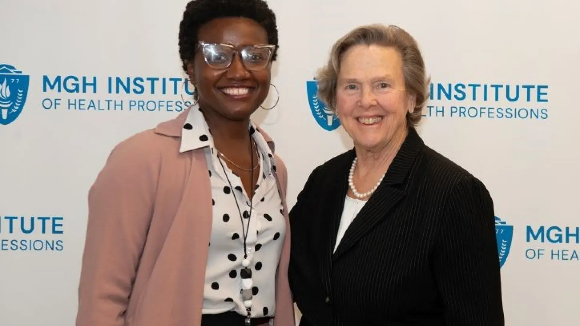 Two women pose and smile