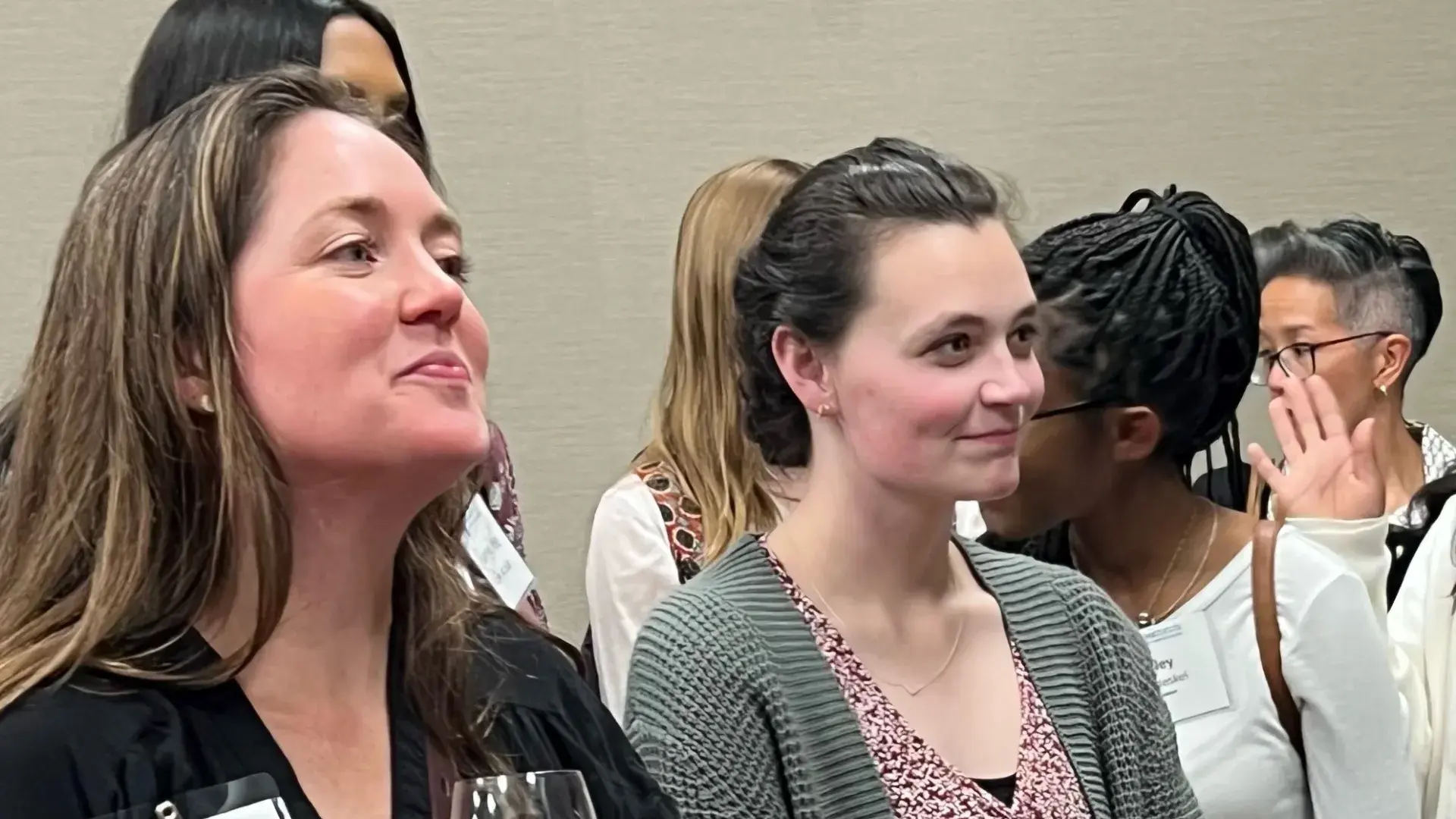 two women smile and stand