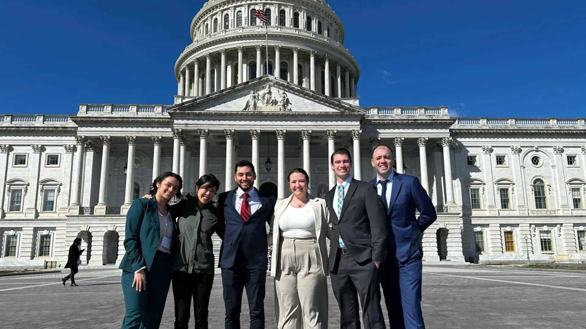 man stands with students outside the capitol