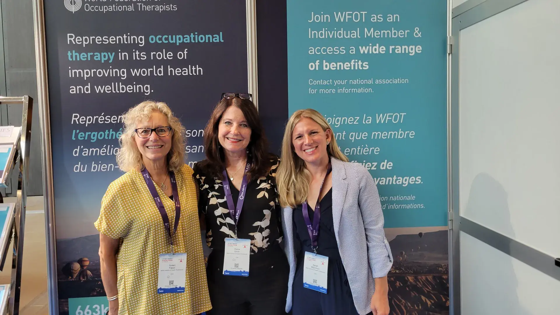 three women stand in front of a banner
