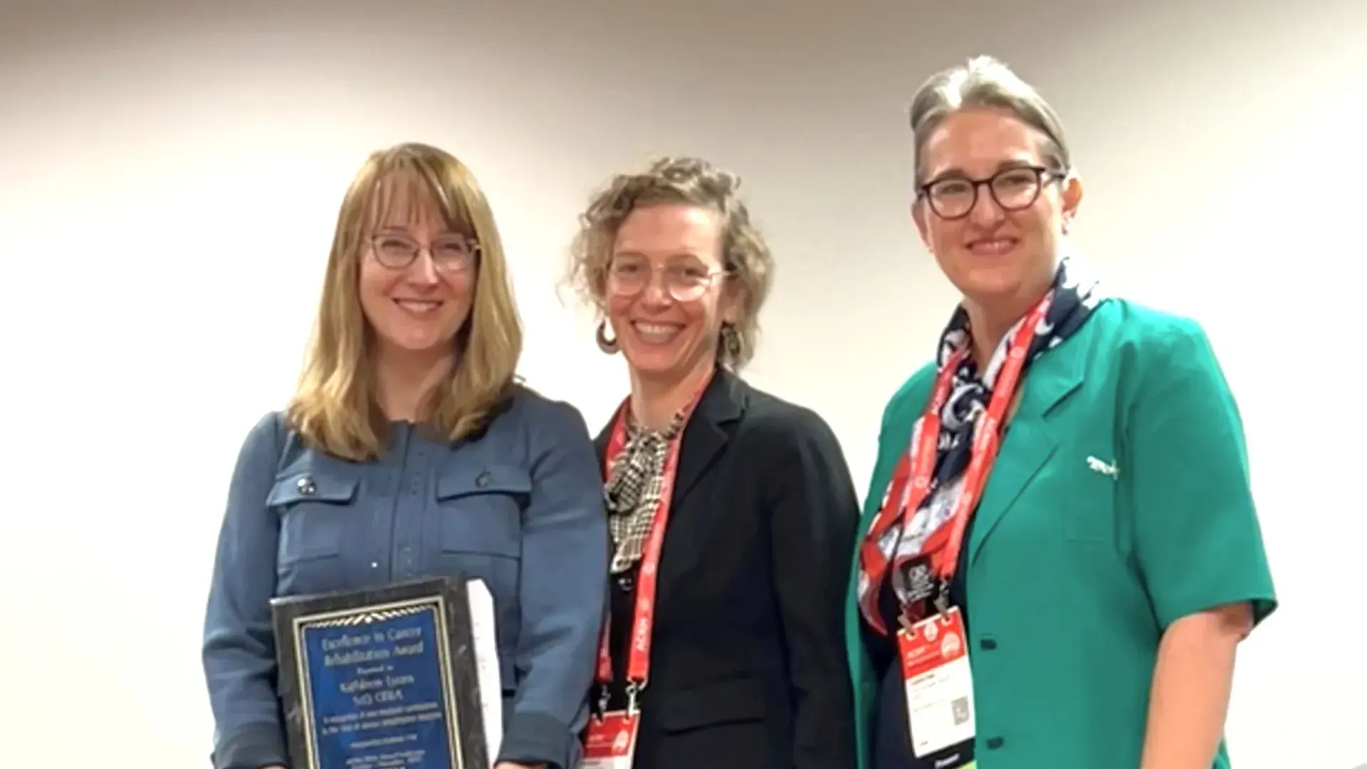 Three women standing and smiling