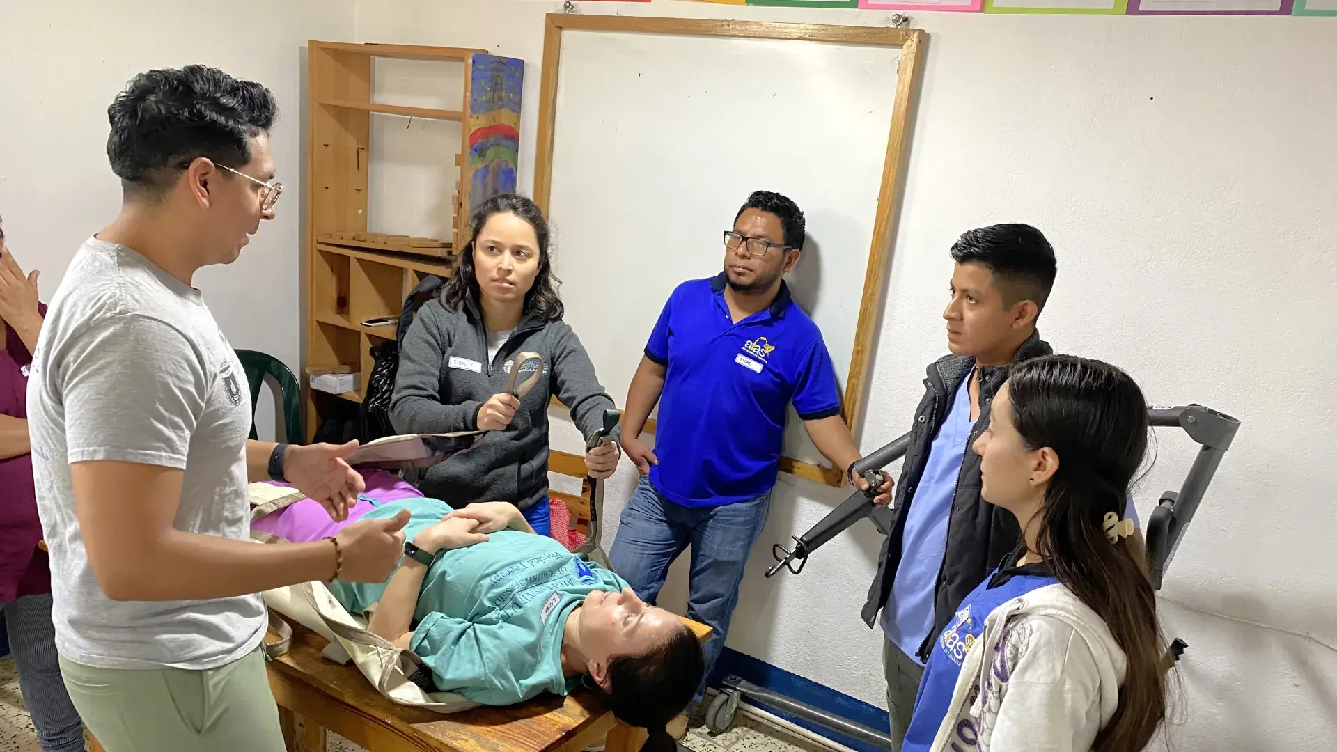 People being instructed on assistant a patient.