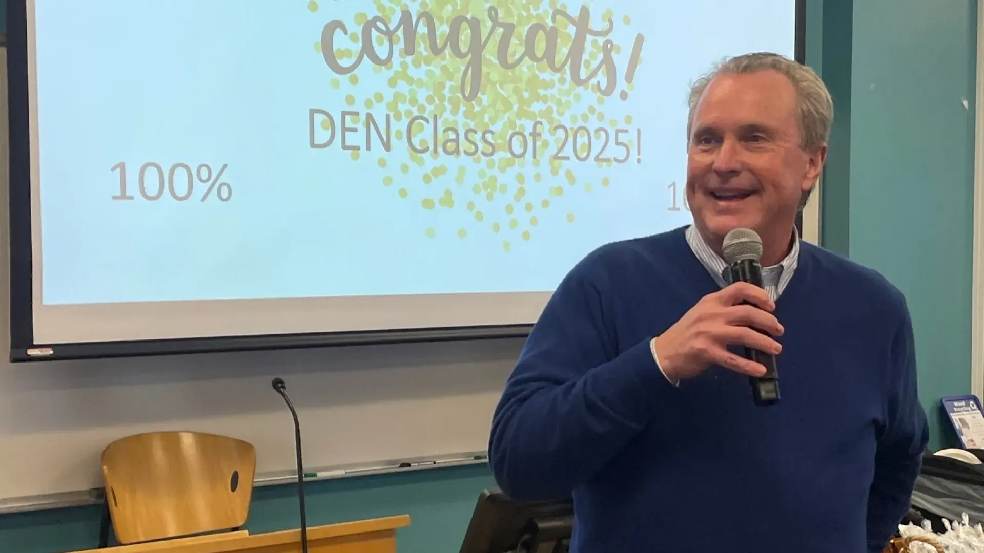 Keynote speaker addressing MGH IHP Class of 2025 during NCLEX celebration for 100% first-time pass rate.