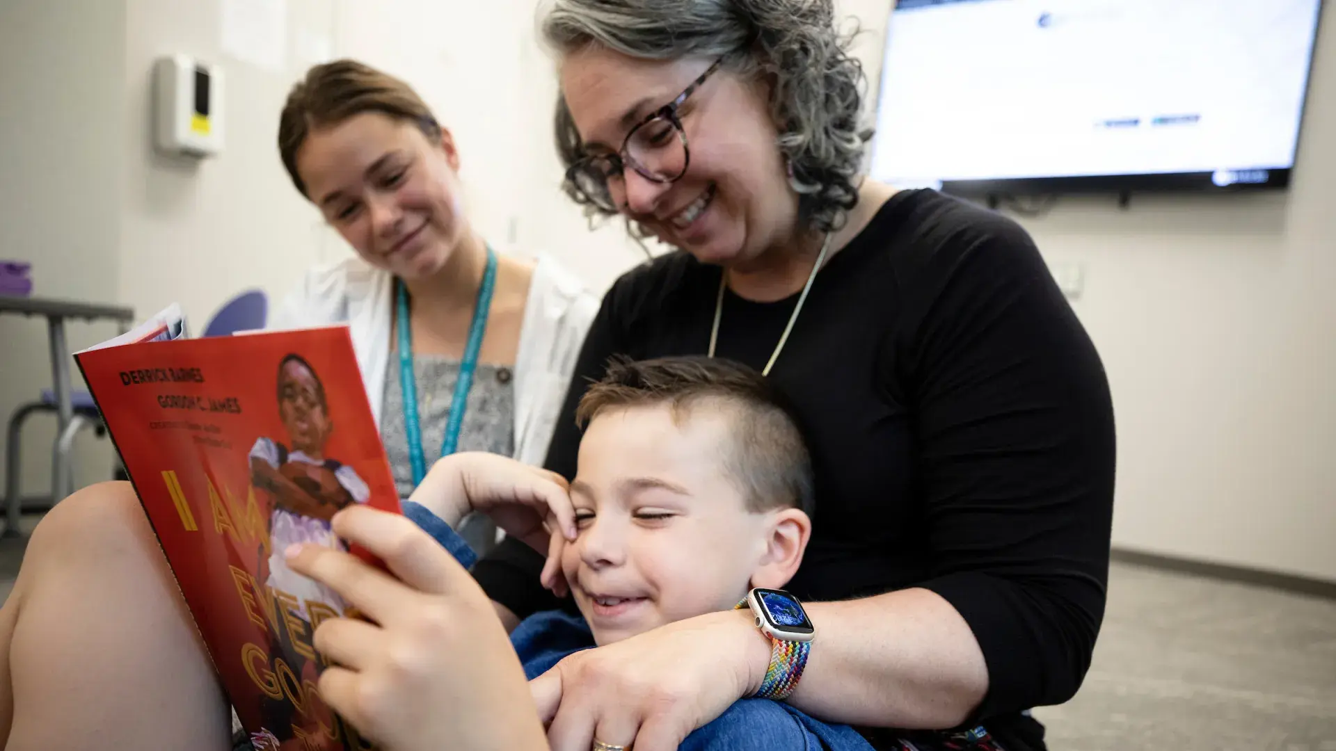 woman sits and reads with child