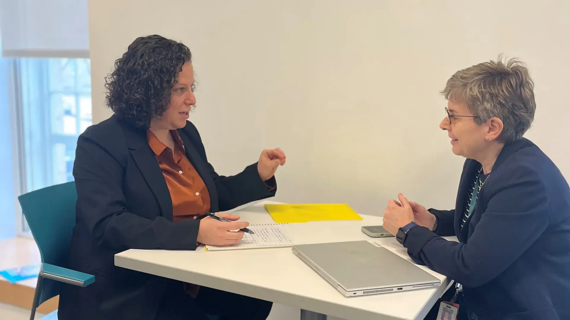 two women sit and discuss