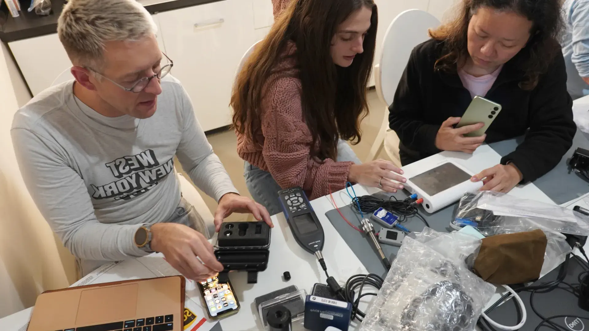AuD students collaborating on audiology equipment setup during a hands-on learning session.