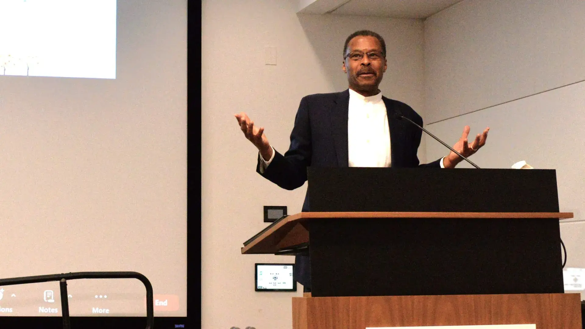 Man gesturing at podium during a talk