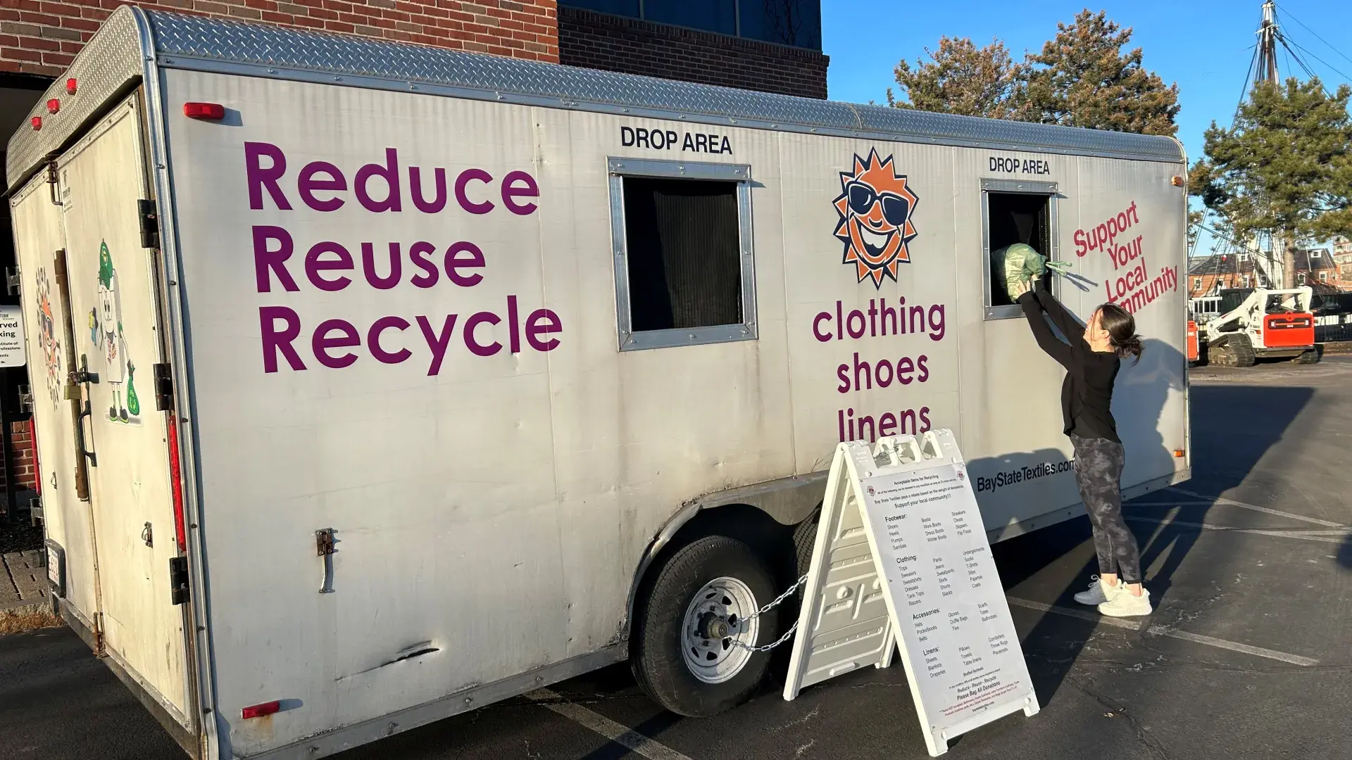 woman stands at textile drive truck