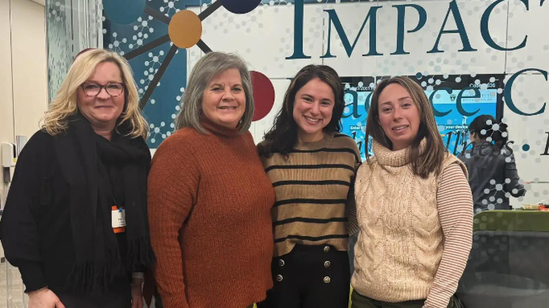 four women smile and pose