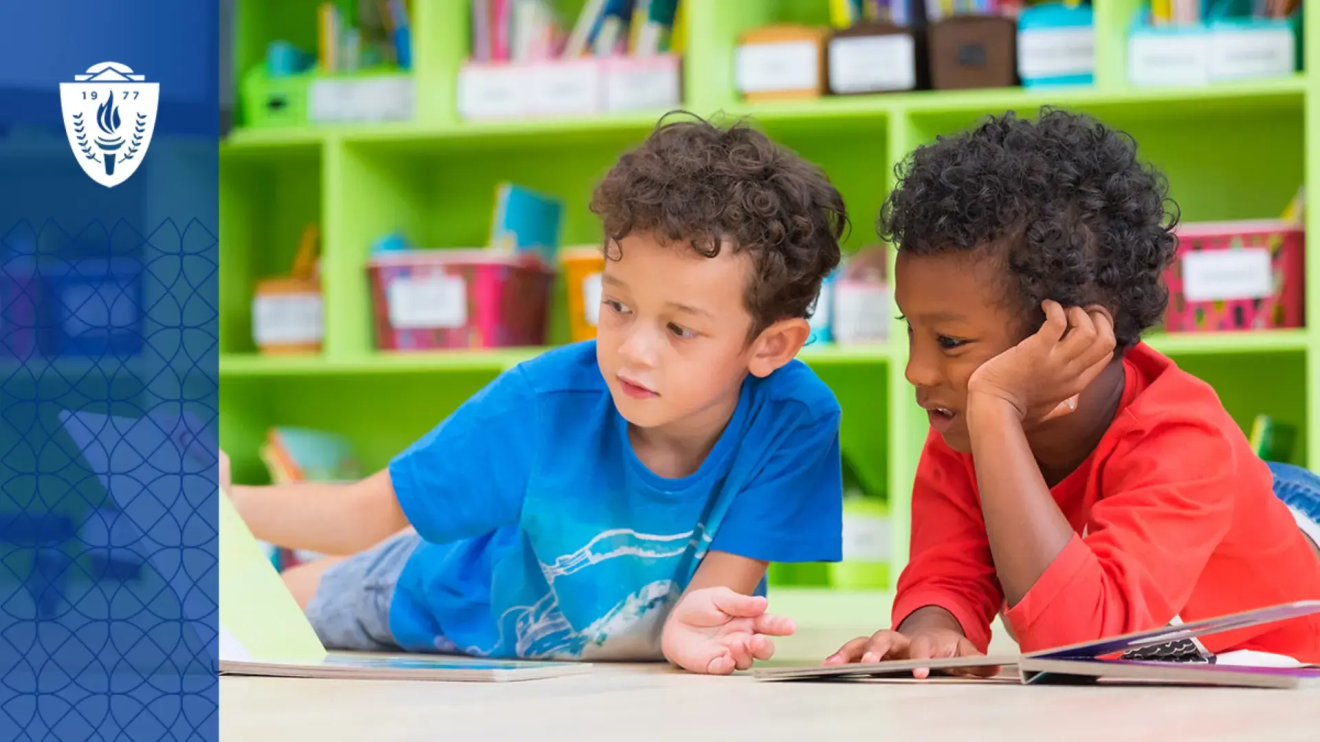 two young boys read a book on the floor in front of a colorful wall of books