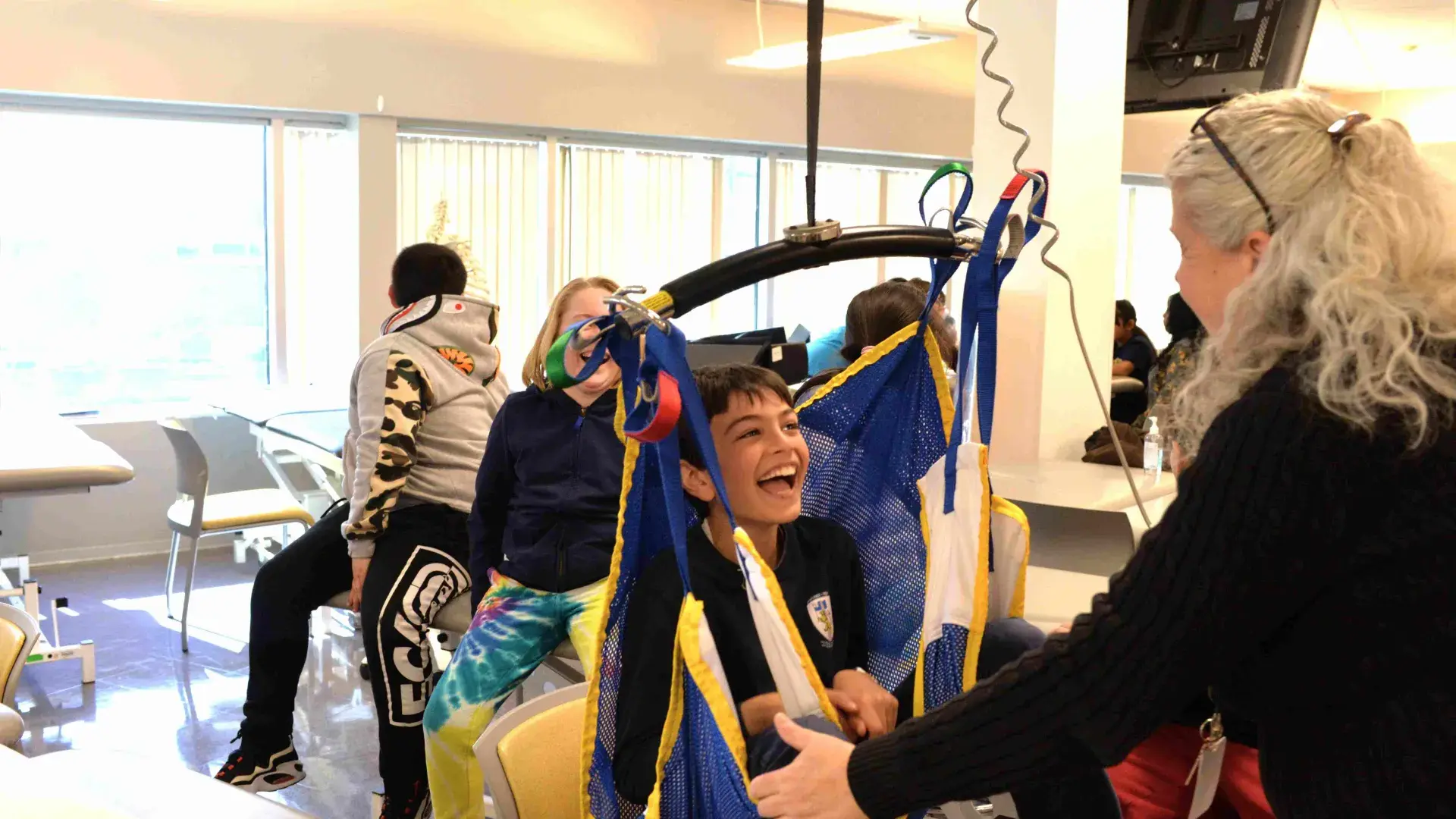 Boy laughs sitting in a PT lift