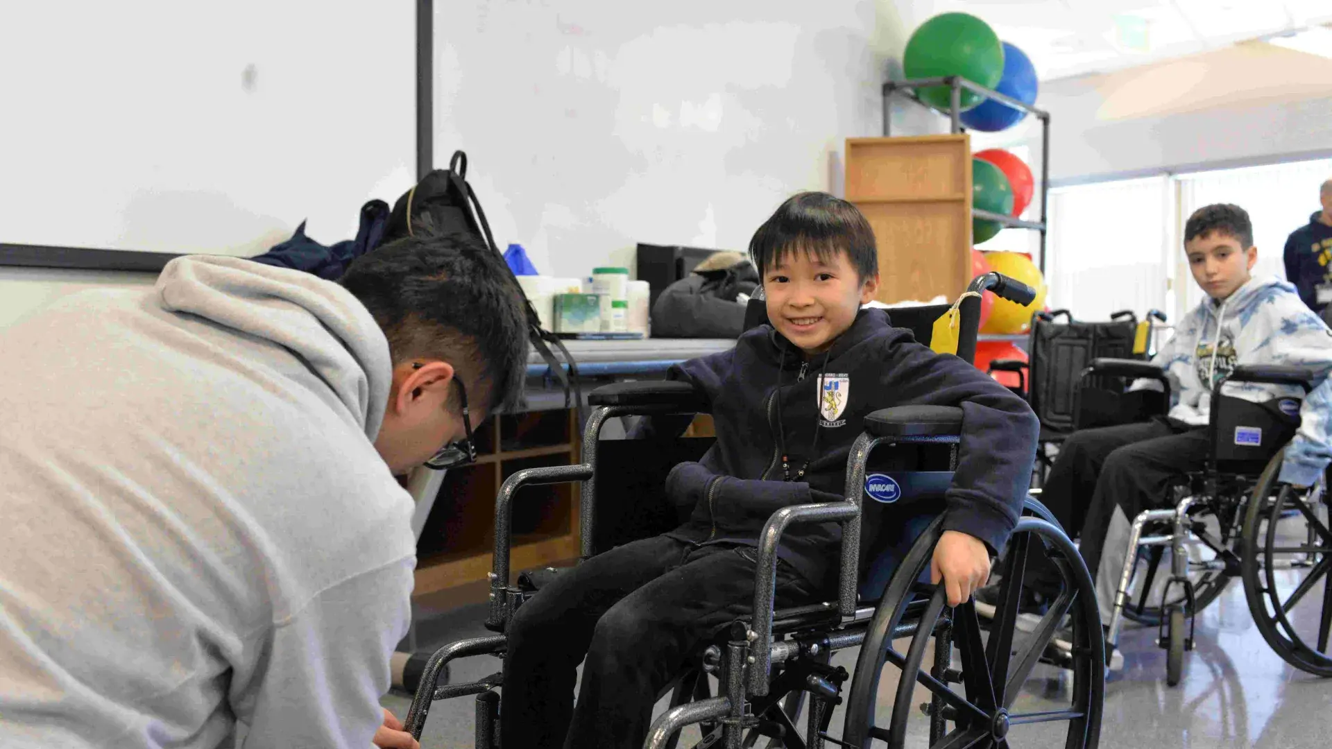 Student smiles sitting in wheelchair