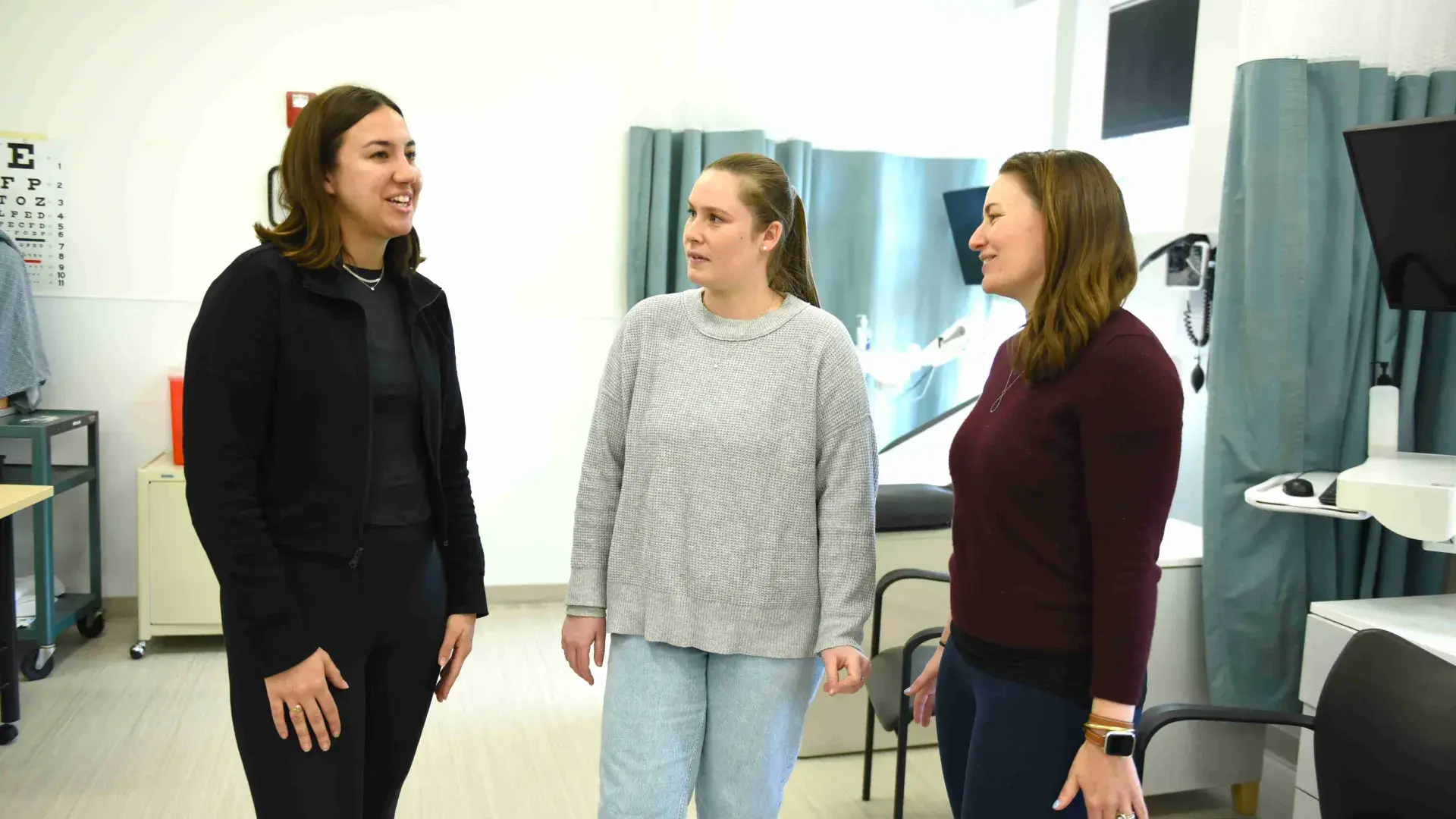Three people talking in nursing lab