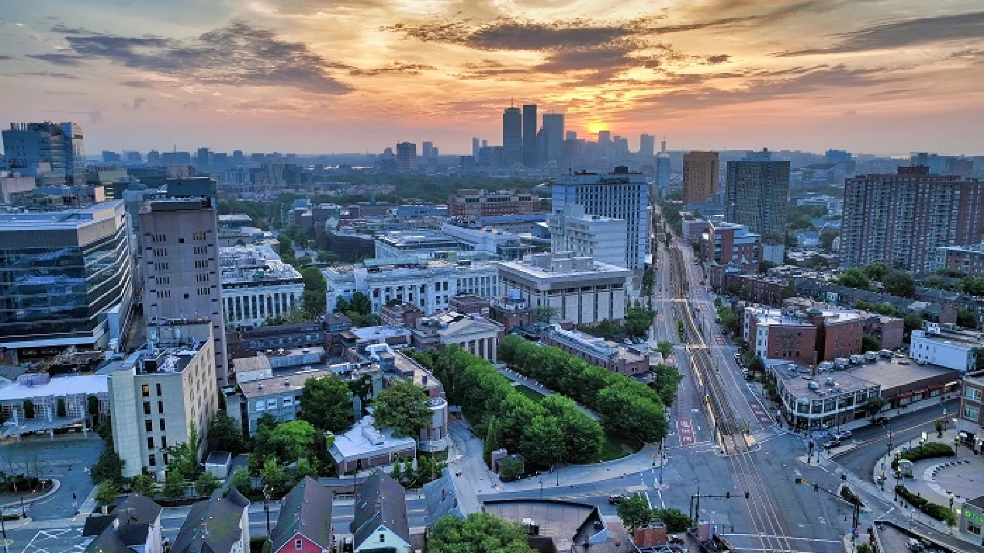 sun rising over boston with a view of medical buildings in the foreground