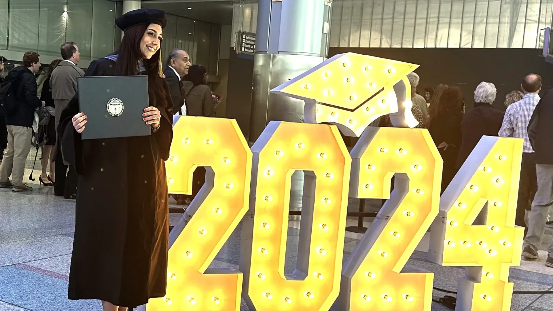 student poses with 2024 sign